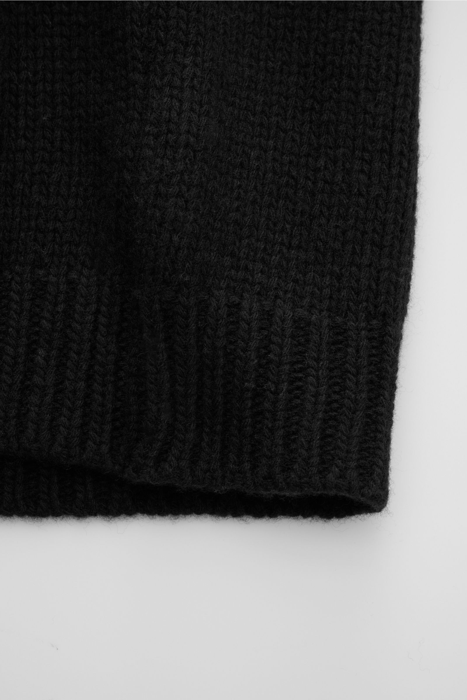 Schwarzer 04651/ A trip in a bag Cardigan 'Bold' aus reiner Lammwolle, Oversized Fit, grobes Strickbild, weicher Griff, Vier-Knopf-Leiste, Detailaufnahme.