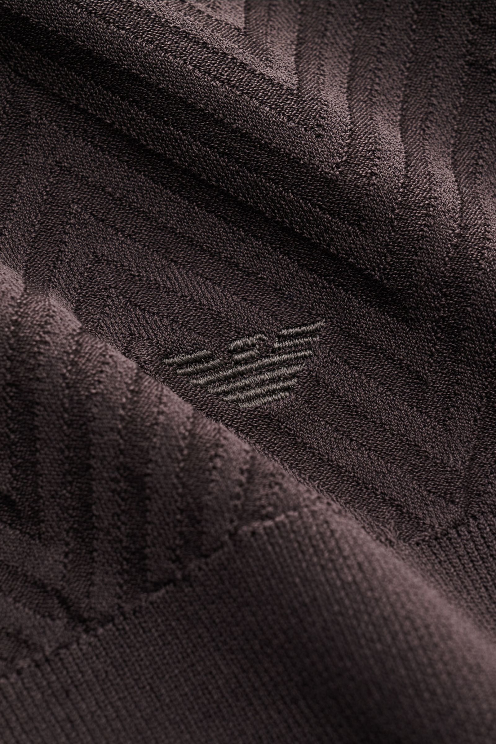 Close-up front view of the tonal logo-stitching and herringbone knit pattern on the Emporio Armani Strickjacke dunkelgrau cardigan.

Für alle, die dezente Details und stilvolles Design schätzen: Diese Strickjacke von EMPORIO ARMANI kombiniert feinstes 