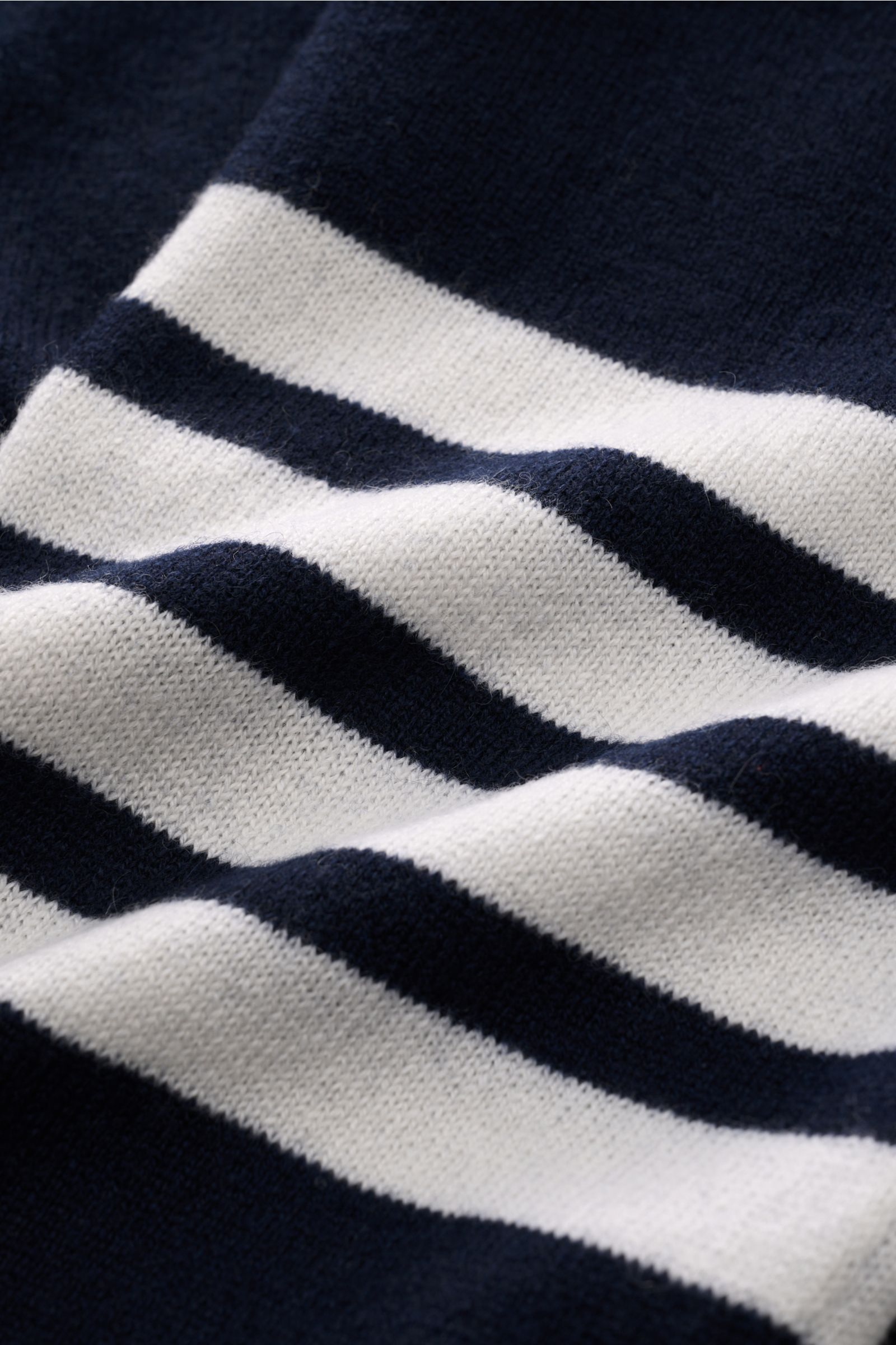 Close-up front view of the Thom Browne Cashmere Cardigan navy showing soft, fine knit stripes in navy and white, highlighting pure cashmere texture.

Description: Vielseitiger Style-Favorit: Der Cashmere Cardigan von THOM BROWNE kombiniert luxuriöse Ma