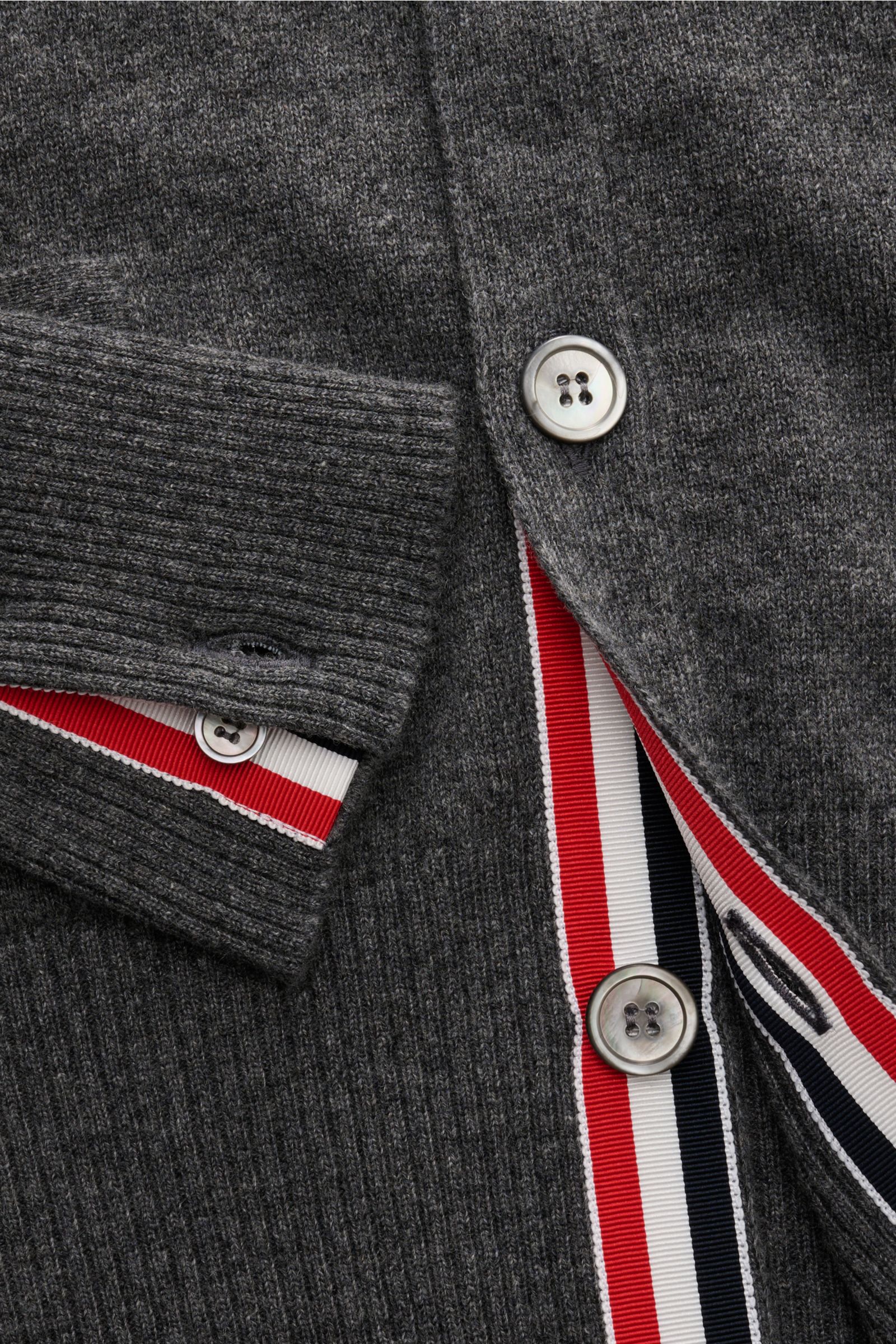 Close-up front view of Thom Browne Cashmere Cardigan dunkelgrau meliert showing dark grey melange cashmere fabric, button placket with red, white, and blue trim, ribbed cuffs, and silver buttons, highlighting soft texture and fine knit.

Vielseitiger S