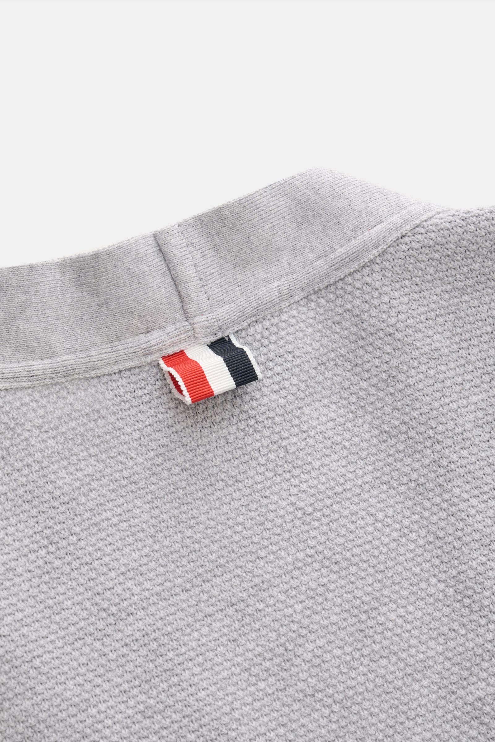 Close-up rear view of the Thom Browne Cardigan light grey mottled showing textured knit fabric and tricolour signature woven label.