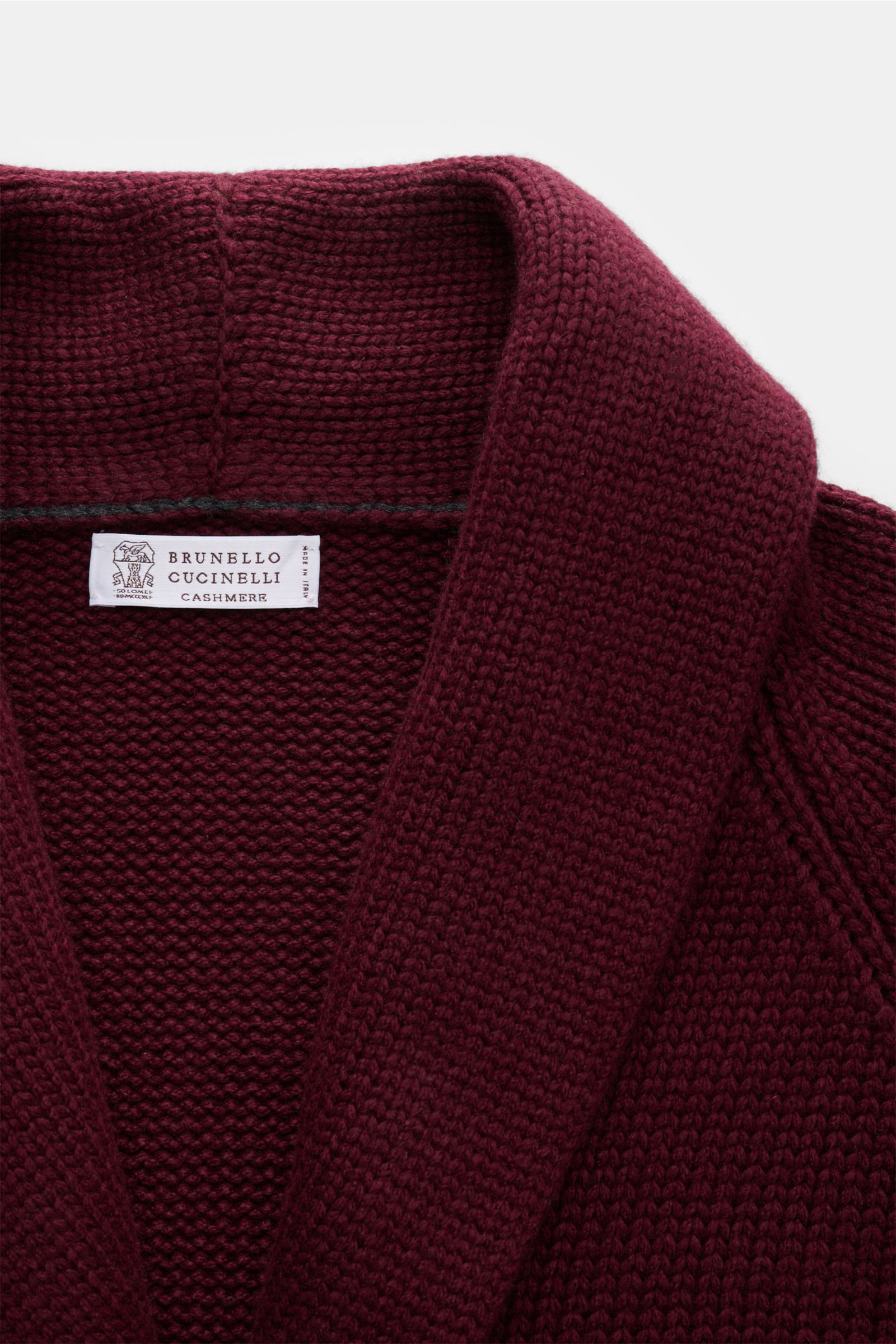Brunello Cucinelli Cashmere Cardigan bordeaux in Nahaufnahme von oben, mit Schalkragen, mittlerem Strickbild, glatter Knopfleiste und weichem Griff.