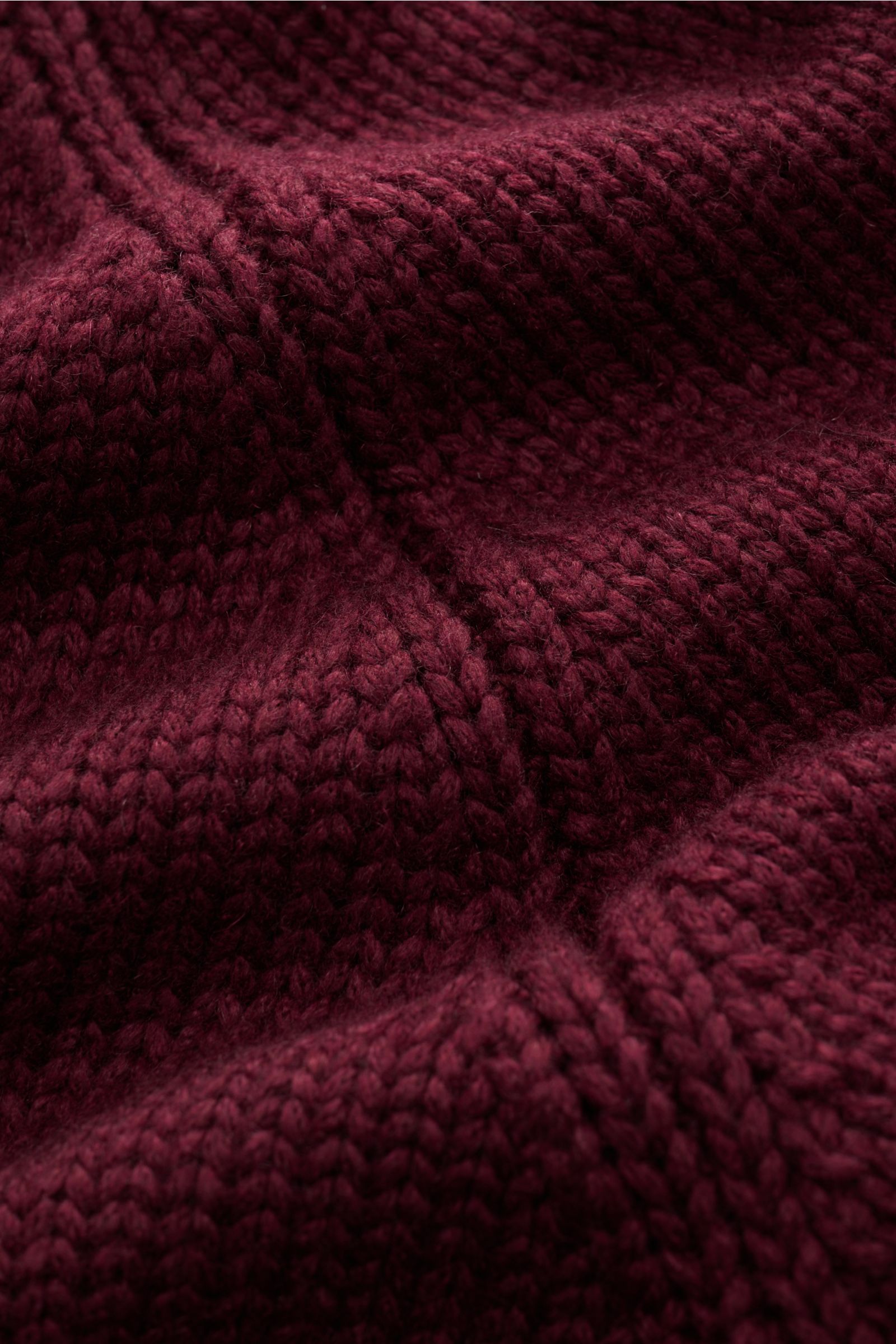 Nahaufnahme des mittelgroben Strickbildes des bordeauxfarbenen Brunello Cucinelli Cashmere Cardigan mit Schalkragen, glatter Knopfleiste und weichem Griff.