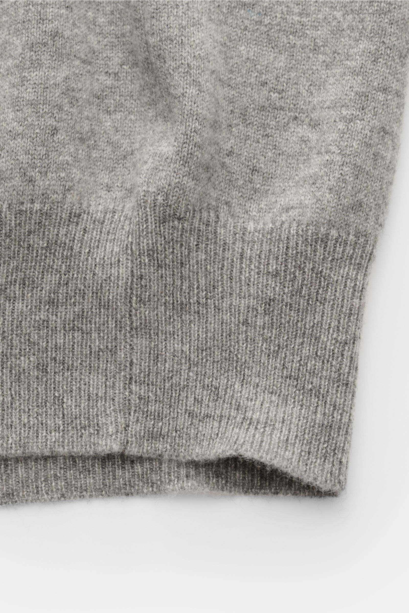 Close-up front view of the lower part of the Bruno Manetti Cashmere cardigan grey melange, showcasing pure cashmere, soft feel, fine knit, regular fit, V-neck, six-button placket, and comfortable ribbed bands.