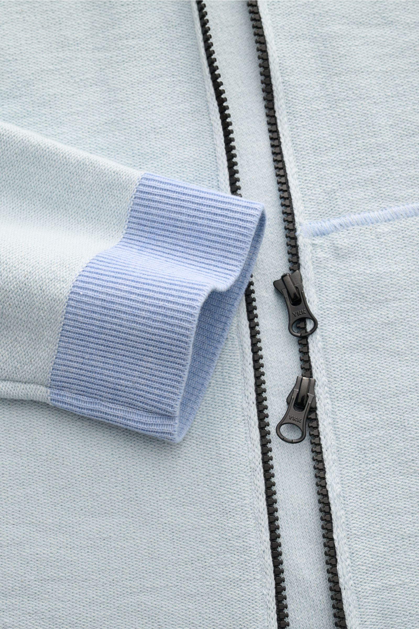 Close-up front view of Stone Island Sweatjacke pastellblau showing zippered front and ribbed cuff in light blue knit with soft texture.

Strick mit Twist: Die sportive Jacke mit Kapuze im modernen Linksstrick von STONE ISLAND wird zum idealen Freizeitb