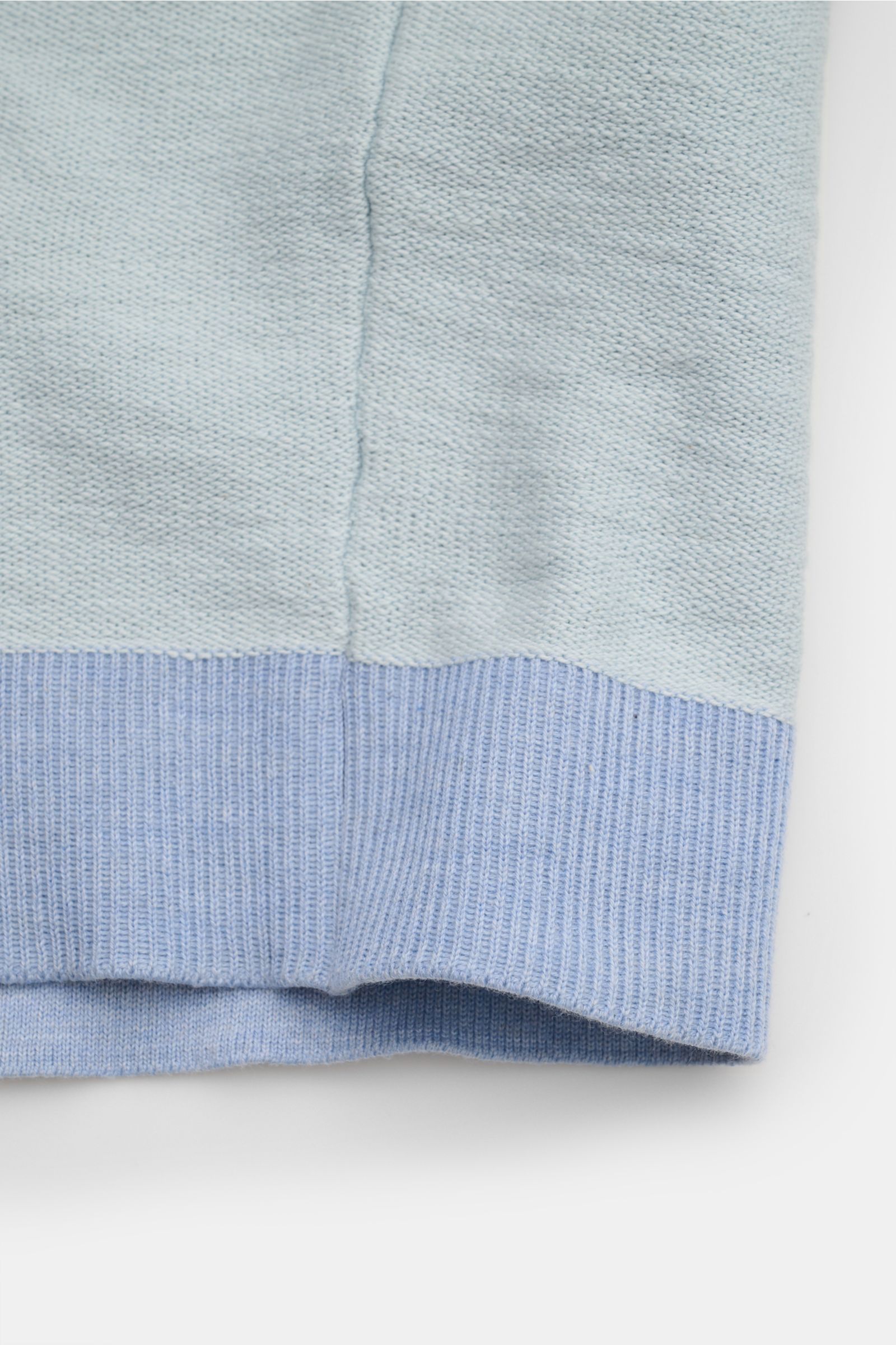 Close-up view of the hem and ribbed cuff of the Stone Island Sweatjacke pastellblau in modern left-knit structure with cotton and microfiber mix. Strick mit Twist: Die sportive Jacke mit Kapuze im modernen Linksstrick von STONE ISLAND wird zum idealen 