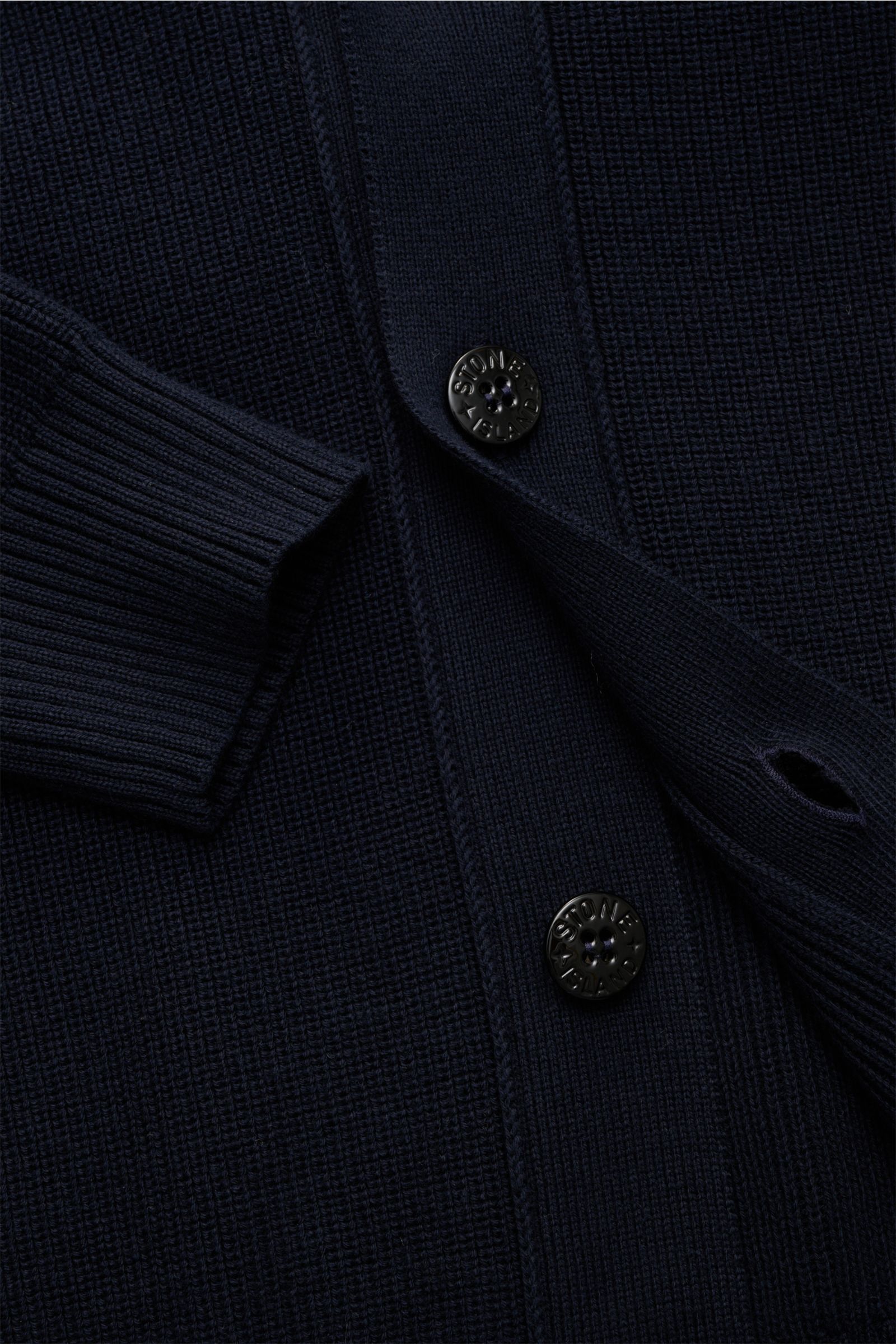Stone Island Cardigan navy in Nahaufnahme, feines Rippstrick-Design aus reiner Baumwolle, vier Knöpfe, V-Ausschnitt, Ärmelbündchen, Kompass-Badge sichtbar.