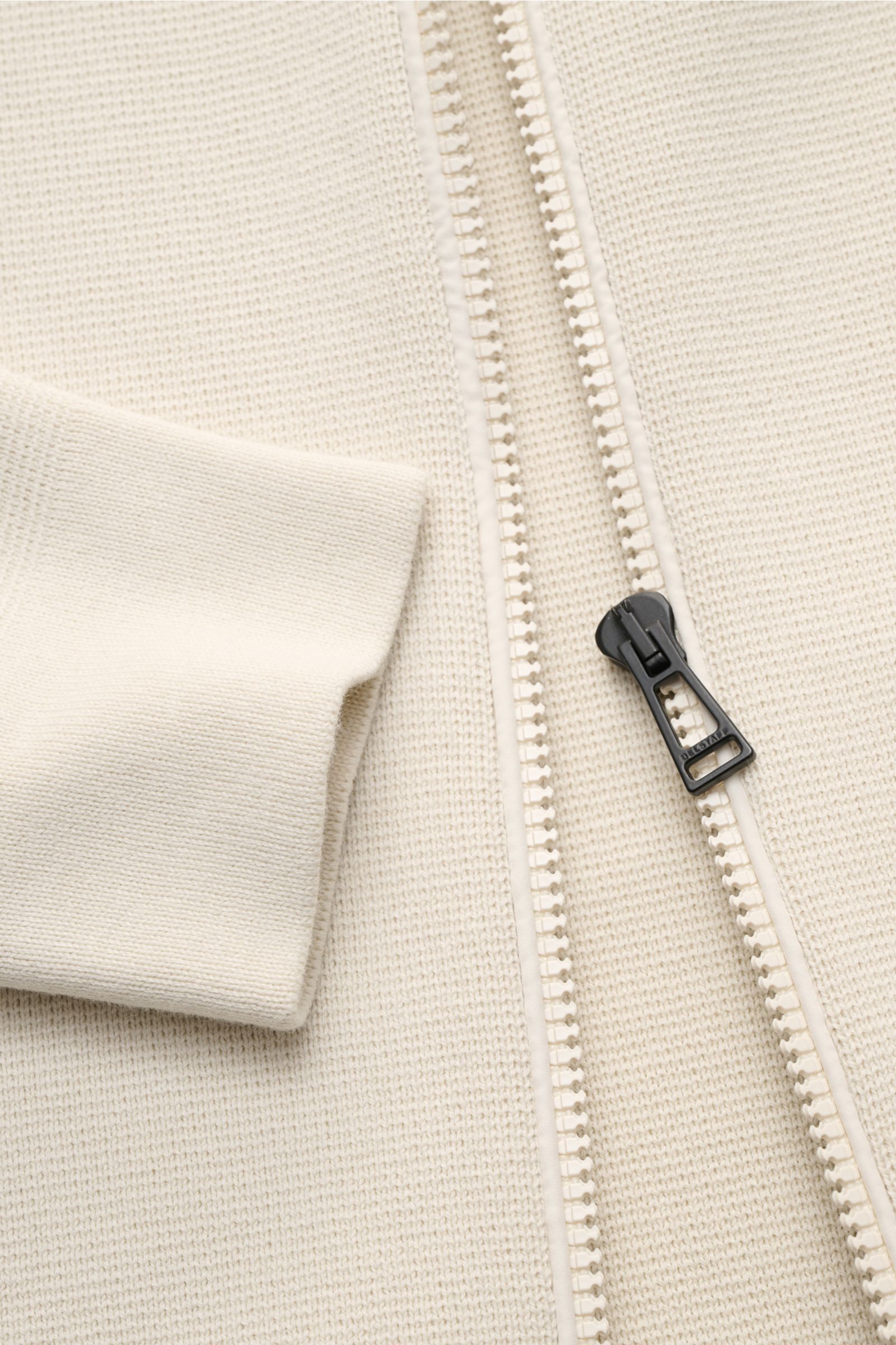 Belstaff Strickjacke 'Verge' creme, Slim Fit aus reiner Baumwolle, feines Strickbild, mit robustem Reißverschluss und Stehkragen, Nahaufnahme frontal.