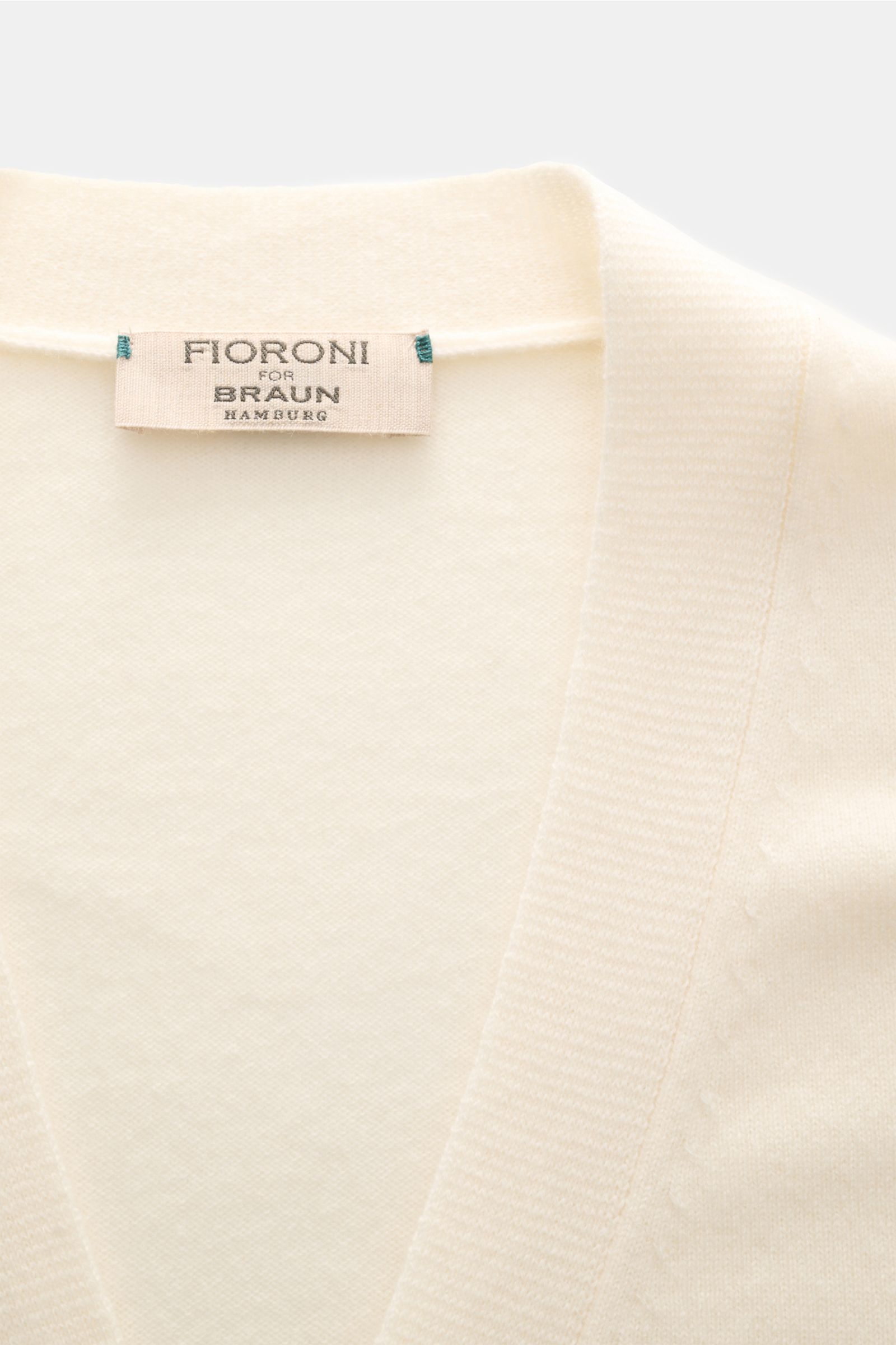 Close-up front view of Fioroni Cashmere cardigan cream showing fine knit, slim fit, smooth button placket, and flexible ribbed bands. Exquisite craftsmanship from Italy: This cardigan by FIORONI is precisely made from fine material in precious baby cashme