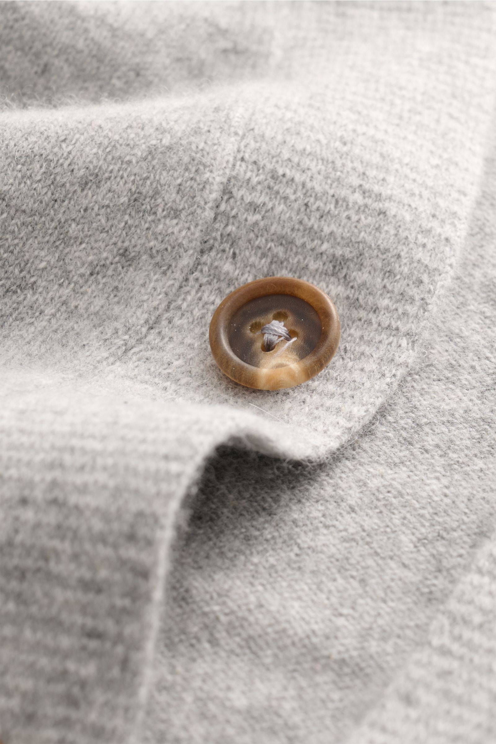 Nahaufnahme des graumelierten Fioroni Cashmere Cardigan mit Fokus auf Knopf und feinem Strickbild, weicher Baby-Cashmere, Slim Fit.