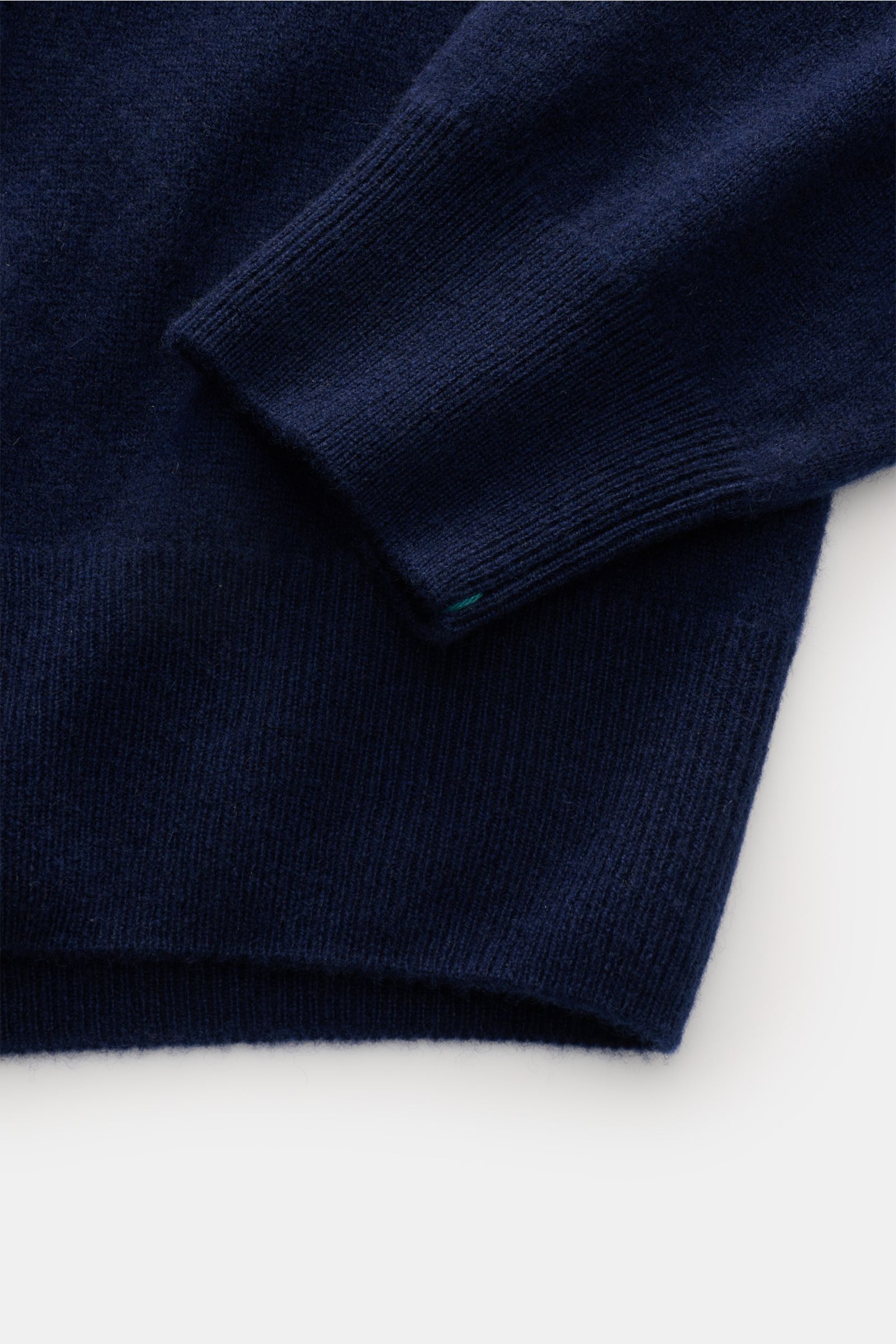 Close-up of the sleeve and hem from a top-down perspective showing the fine knit and ribbed bands of the Fioroni Cashmere cardigan dark blue, crafted in Italy from pure baby cashmere with a soft feel and smooth button placket.