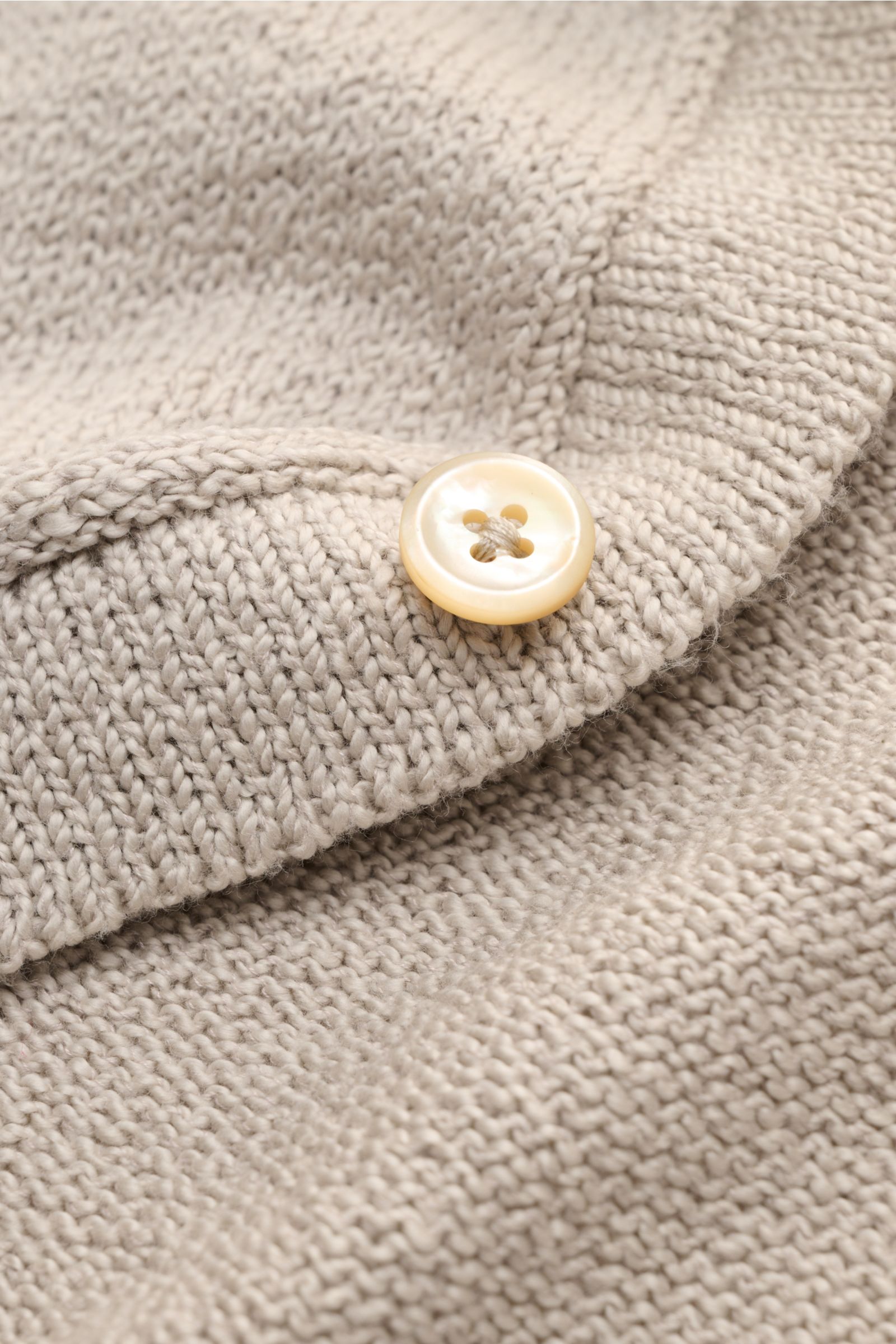 Nahaufnahme des Fioroni Cardigan beige aus mittelfeinem Strick mit Umlegekragen, Acht-Knopf-Leiste und flexiblen Rippbündchen, weiche Baumwolle.