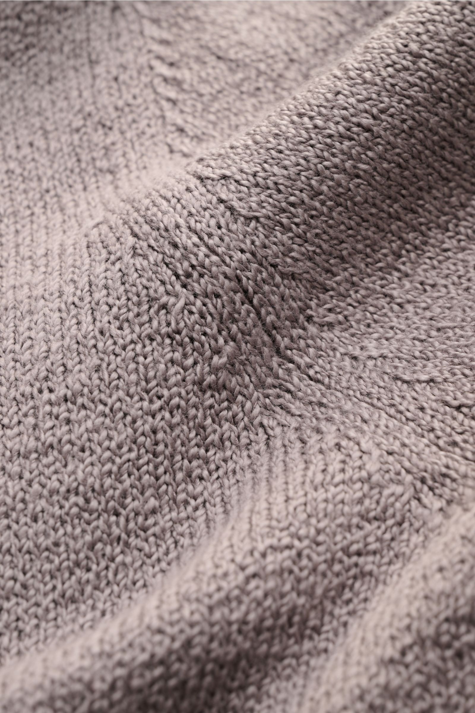 Nahaufnahme des mittelfeinen Strickbilds und der weichen Baumwolle des Fioroni Cardigan grau, fotografiert aus schräger Perspektive.