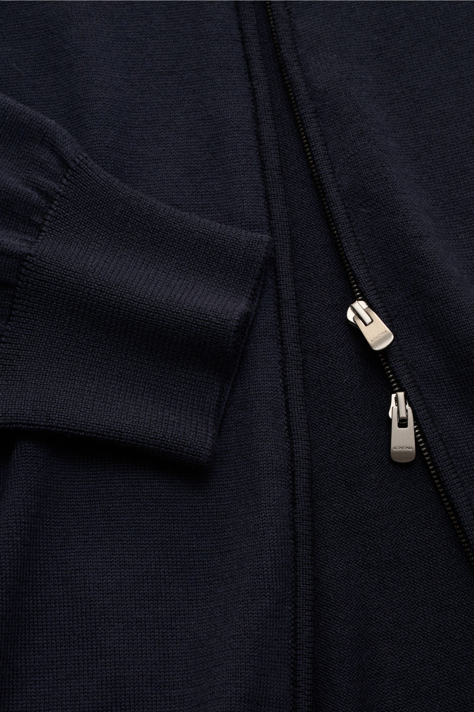 Nahaufnahme der Agnona Strickjacke navy aus reiner, weicher Wolle mit Slim Fit, Zwei-Wege-Reißverschluss und Rippbündchen, seitliche Perspektive.