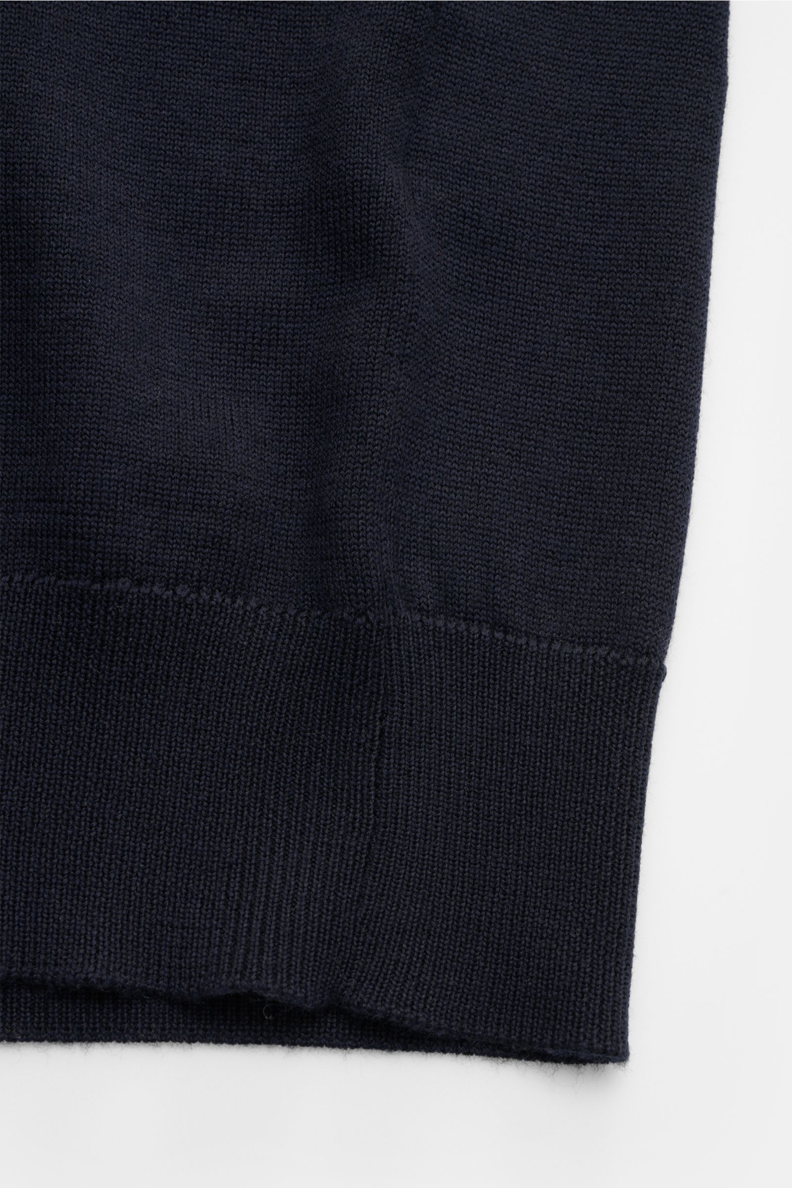 Nahaufnahme der Agnona Strickjacke navy, aus reiner, weicher Wolle mit Slim Fit, Rippbündchen, hoch schließendem Kragen, Zwei-Wege-Reißverschluss und Metall-Logo, seitliche Perspektive.