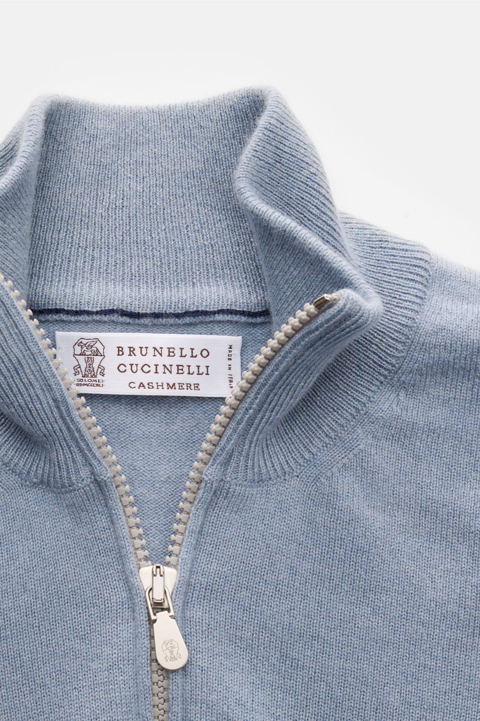 Close-up front view of the Brunello Cucinelli Cashmere Strickjacke rauchblau with open silver two-way zipper and high ribbed collar.

Luxus für die Freizeitgarderobe bietet BRUNELLO CUCINELLI mit dieser Strickjacke aus geschmeidigem Cashmere, veredelt 