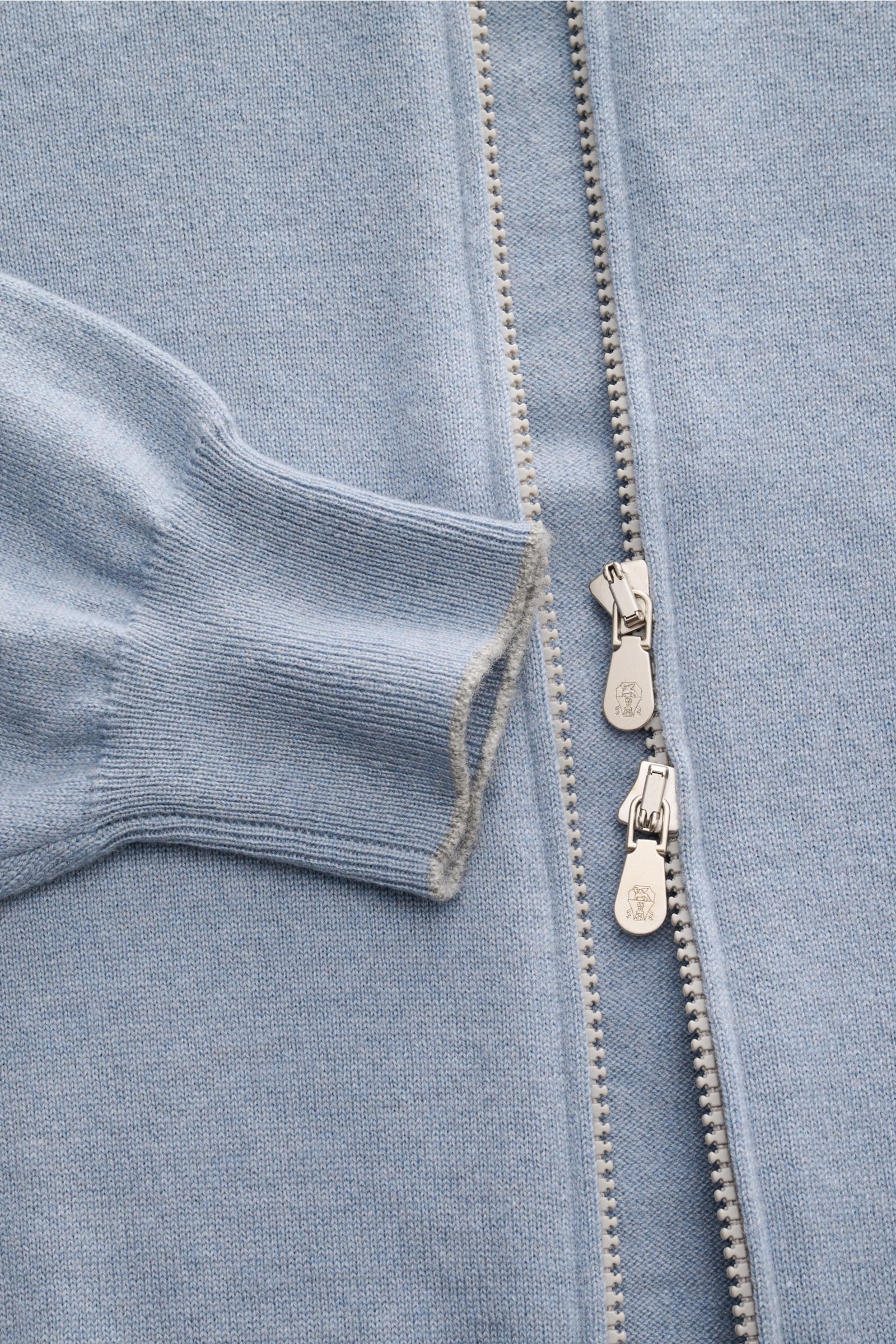 Brunello Cucinelli Cashmere Strickjacke rauchblau shown from a close-up top-down view, highlighting the soft cashmere fabric, ribbed cuff with fine contrast edge, and silver two-way zipper.

Luxus für die Freizeitgarderobe bietet BRUNELLO CUCINELLI mit