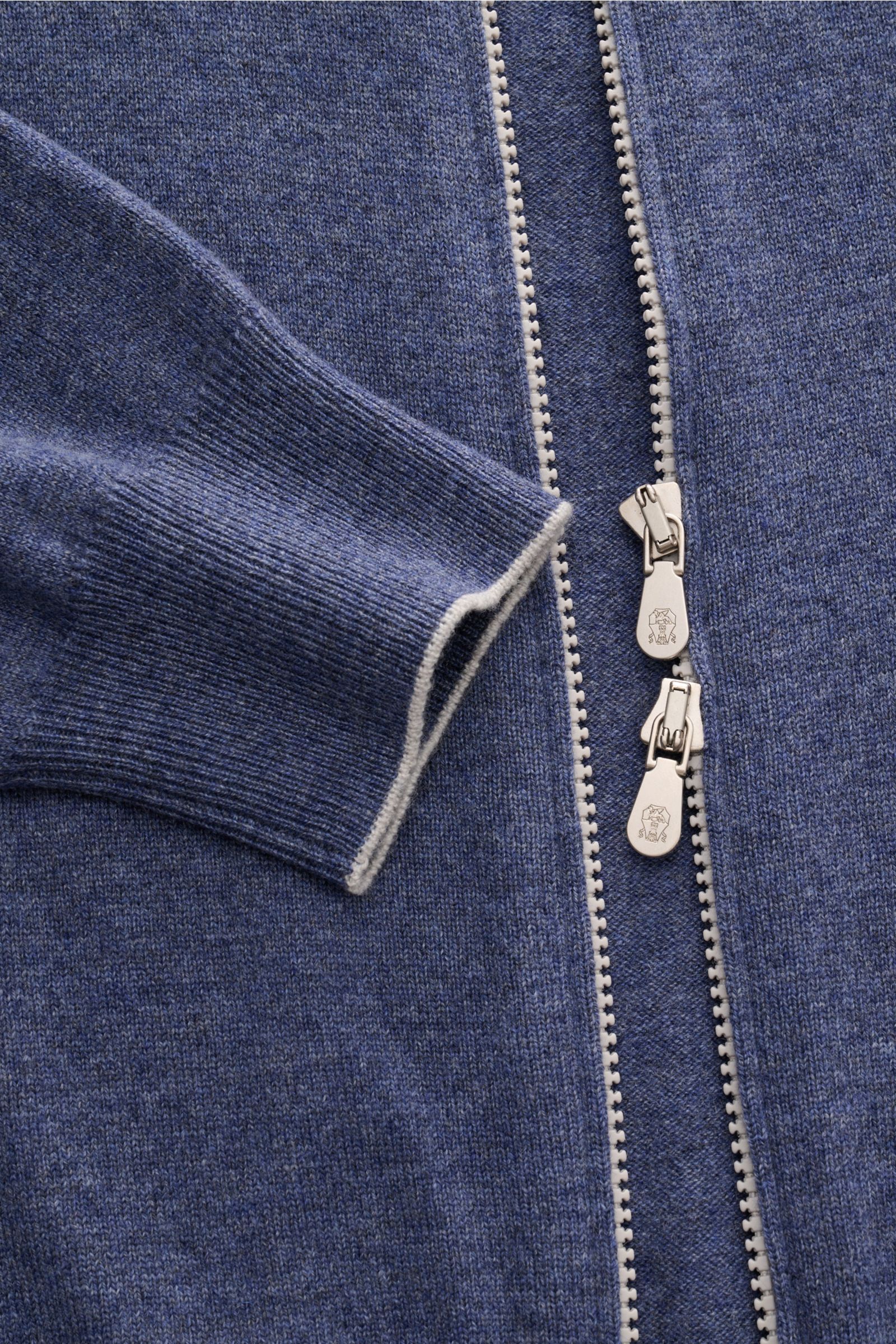 Close-up front view of Brunello Cucinelli Cashmere Strickjacke blau meliert with soft blue melange knit, white contrast edges on cuffs, and dual silver zippers.

Description: Luxus für die Freizeitgarderobe bietet BRUNELLO CUCINELLI mit dieser Strickja