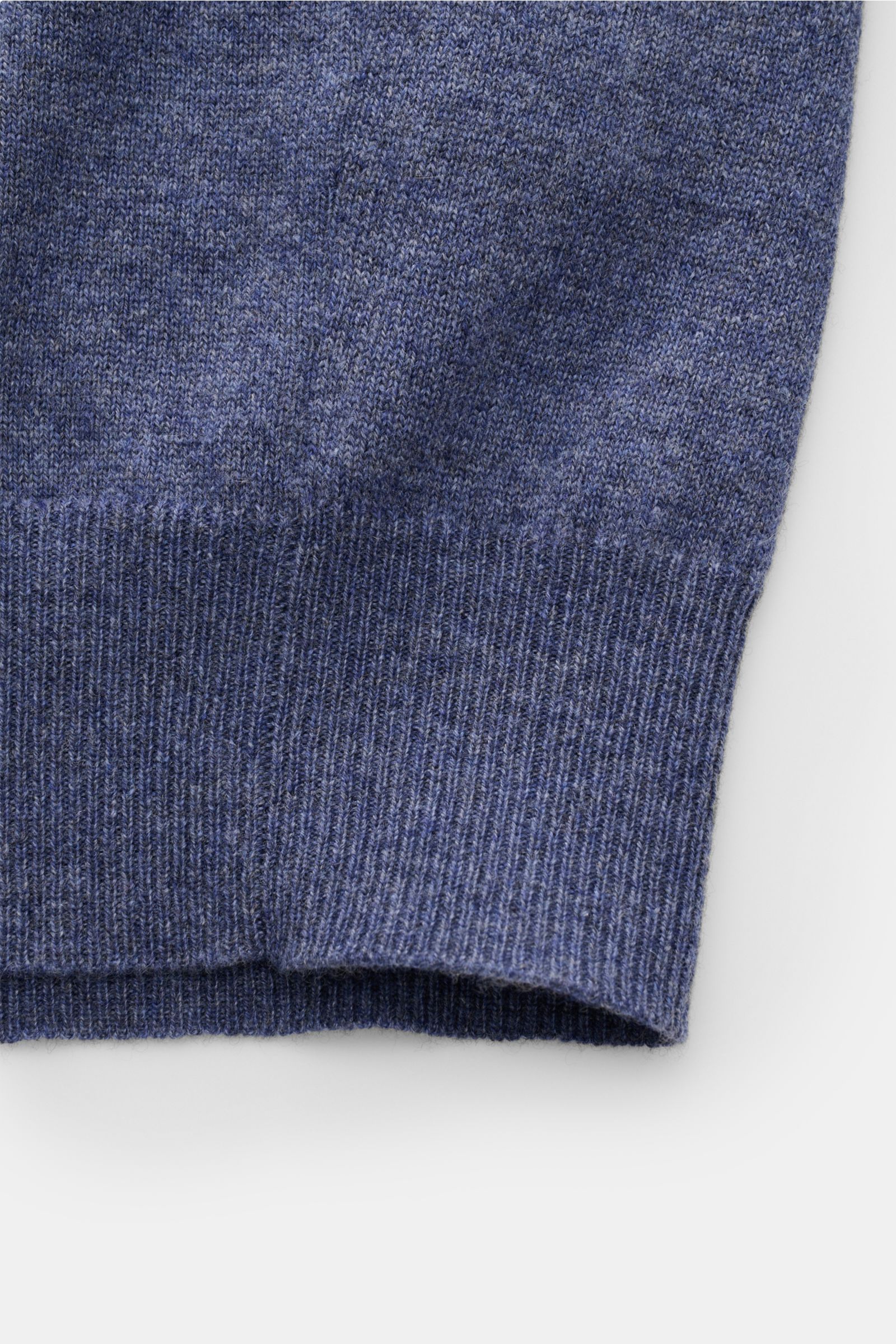 Close-up view of the sleeve cuff of the Brunello Cucinelli Cashmere Strickjacke blau meliert, showcasing soft pure cashmere knit with fine contrast edges and ribbed flexible cuff. 

Luxus für die Freizeitgarderobe bietet BRUNELLO CUCINELLI mit dieser S