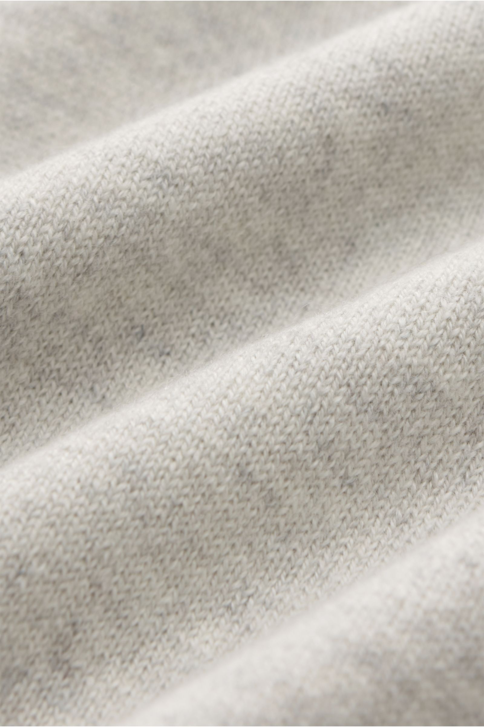 Close-up view of the soft, fine knit texture of the Brunello Cucinelli Cashmere Strickjacke hellgrau meliert, showcasing its light gray melange fabric.

Description: Luxus für die Freizeitgarderobe bietet BRUNELLO CUCINELLI mit dieser Strickjacke aus g