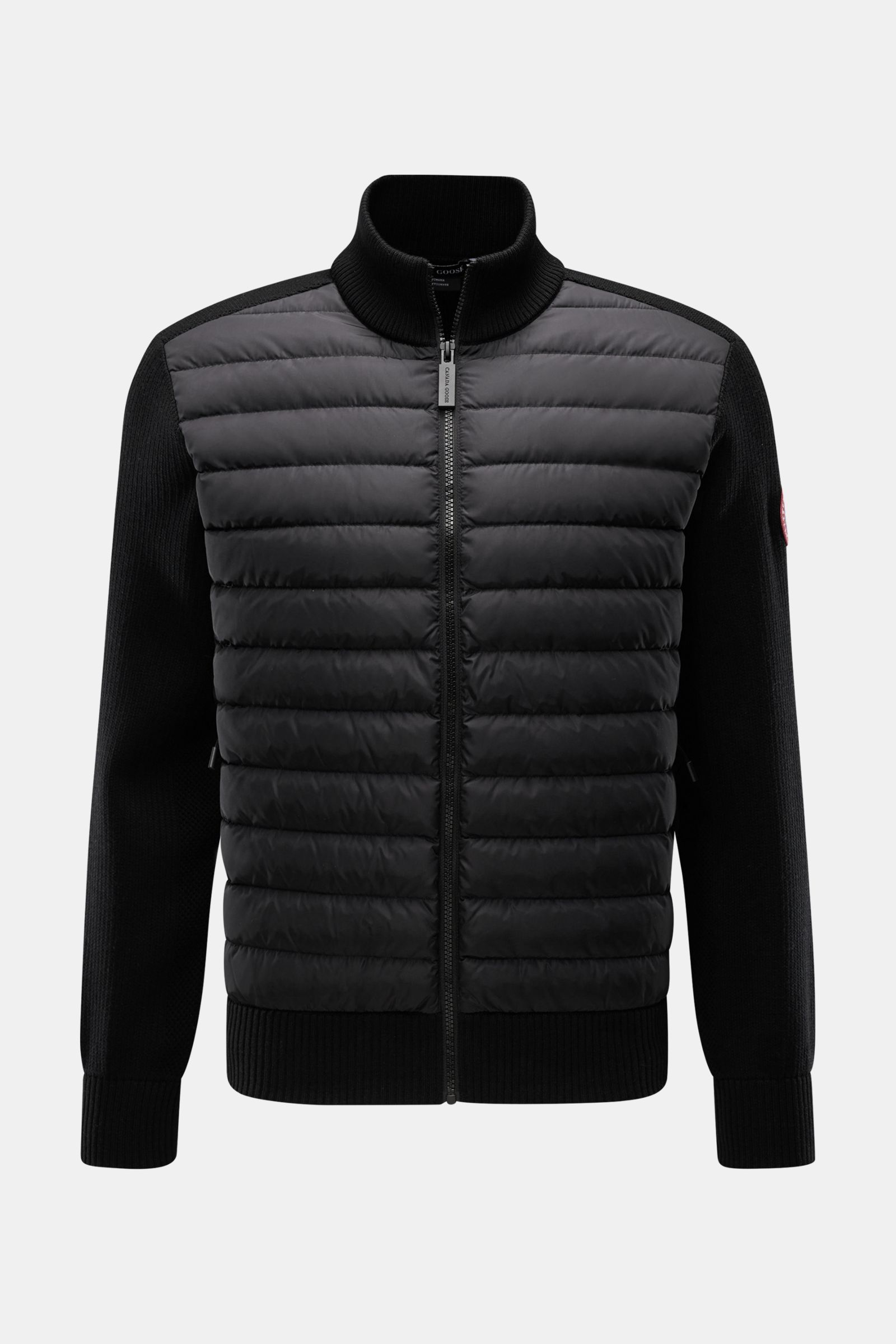 Frontansicht der Canada Goose Strickjacke 'Hybridge Knit' schwarz mit Daunen-Front, Wollstrickärmeln, Stehkragen und Reißverschluss.