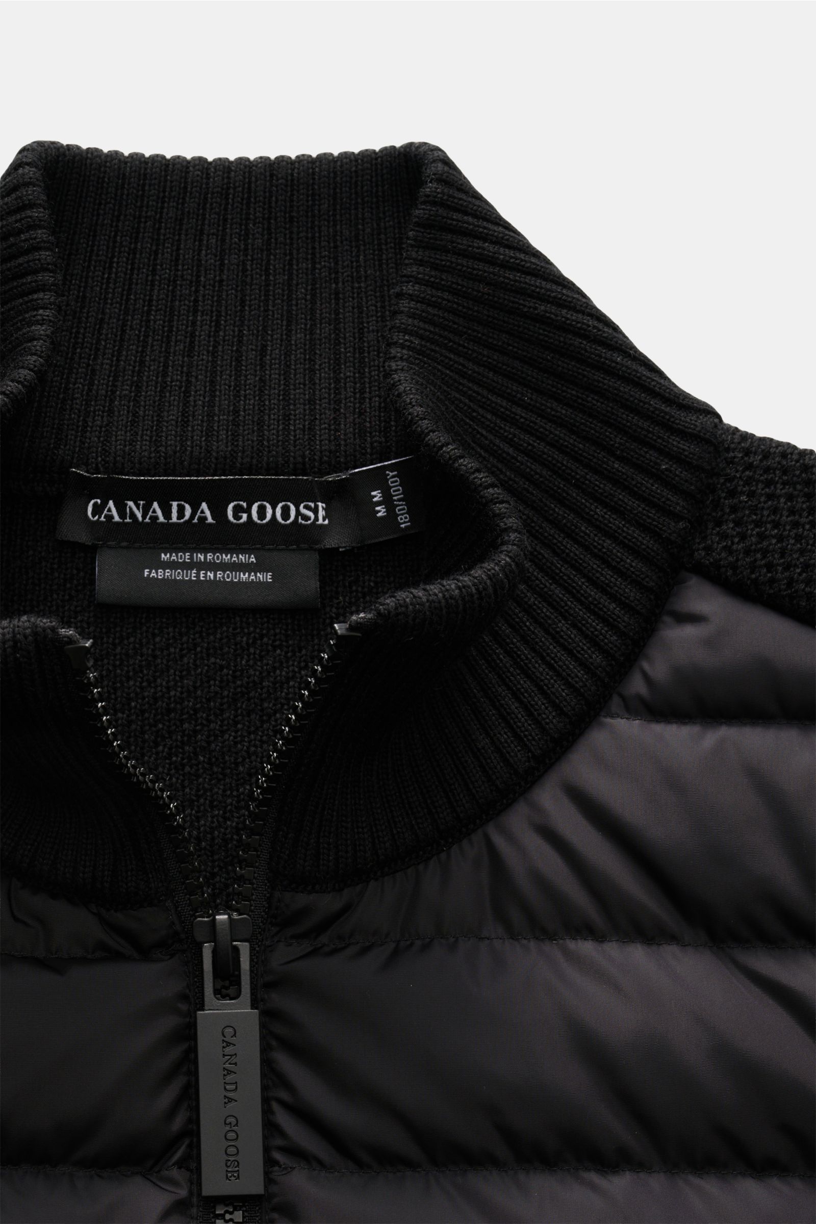 Canada Goose Strickjacke 'Hybridge Knit' schwarz, Detailaufnahme der Daunen-Front, strukturierter Wollstrick, Reißverschluss und Stehkragen.