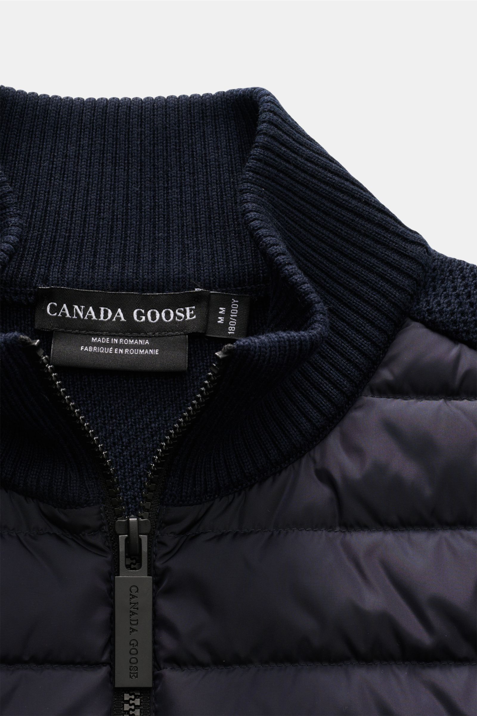 Nahaufnahme der Canada Goose Strickjacke 'Hybridge Knit' navy, von oben fotografiert, mit Daunen-Front, Wollstrick, Reißverschluss und Stehkragen.