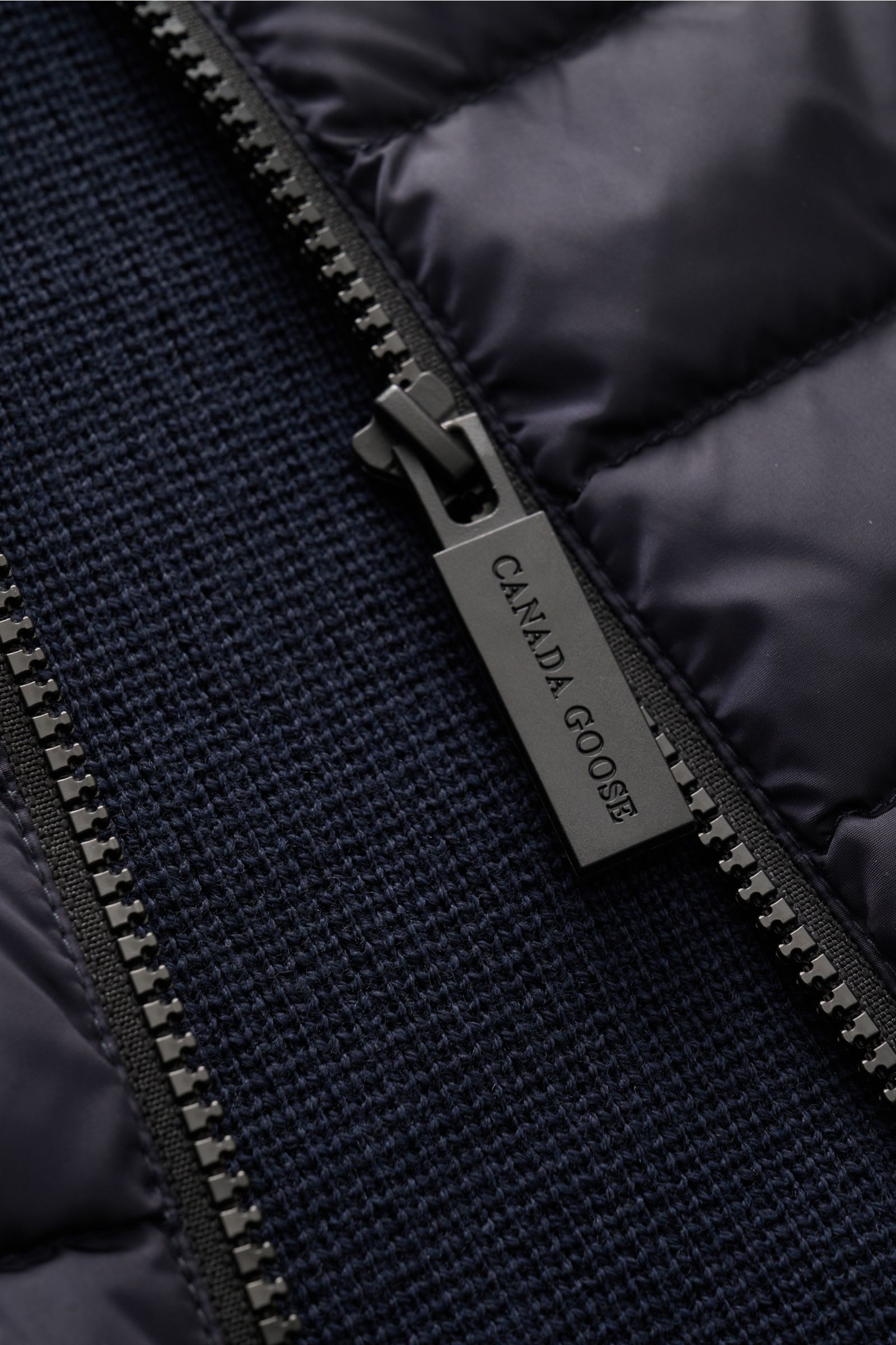 Nahaufnahme der Canada Goose Strickjacke 'Hybridge Knit' navy mit Daunenfront, robustem Reißverschluss und strukturierter Woll-Strickoptik.
