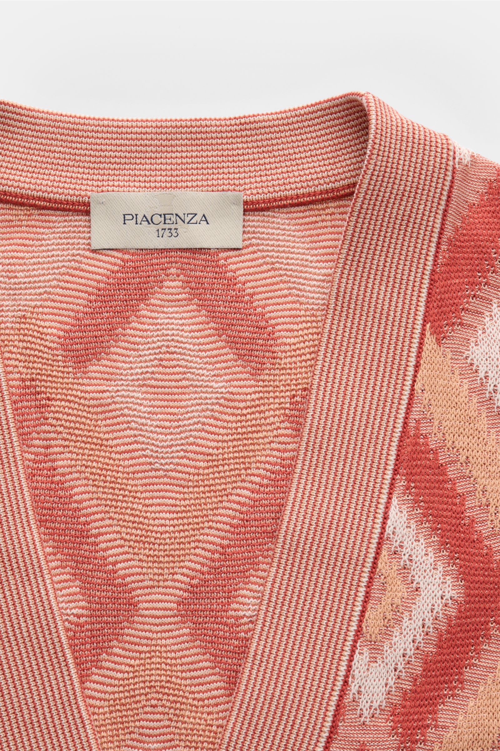 Piacenza 1733 Cardigan rot/apricot/offwhite gemustert, Slim Fit, V-Ausschnitt, Fünf-Knopf-Leiste, luftiges Strickbild, Nahaufnahme von oben.