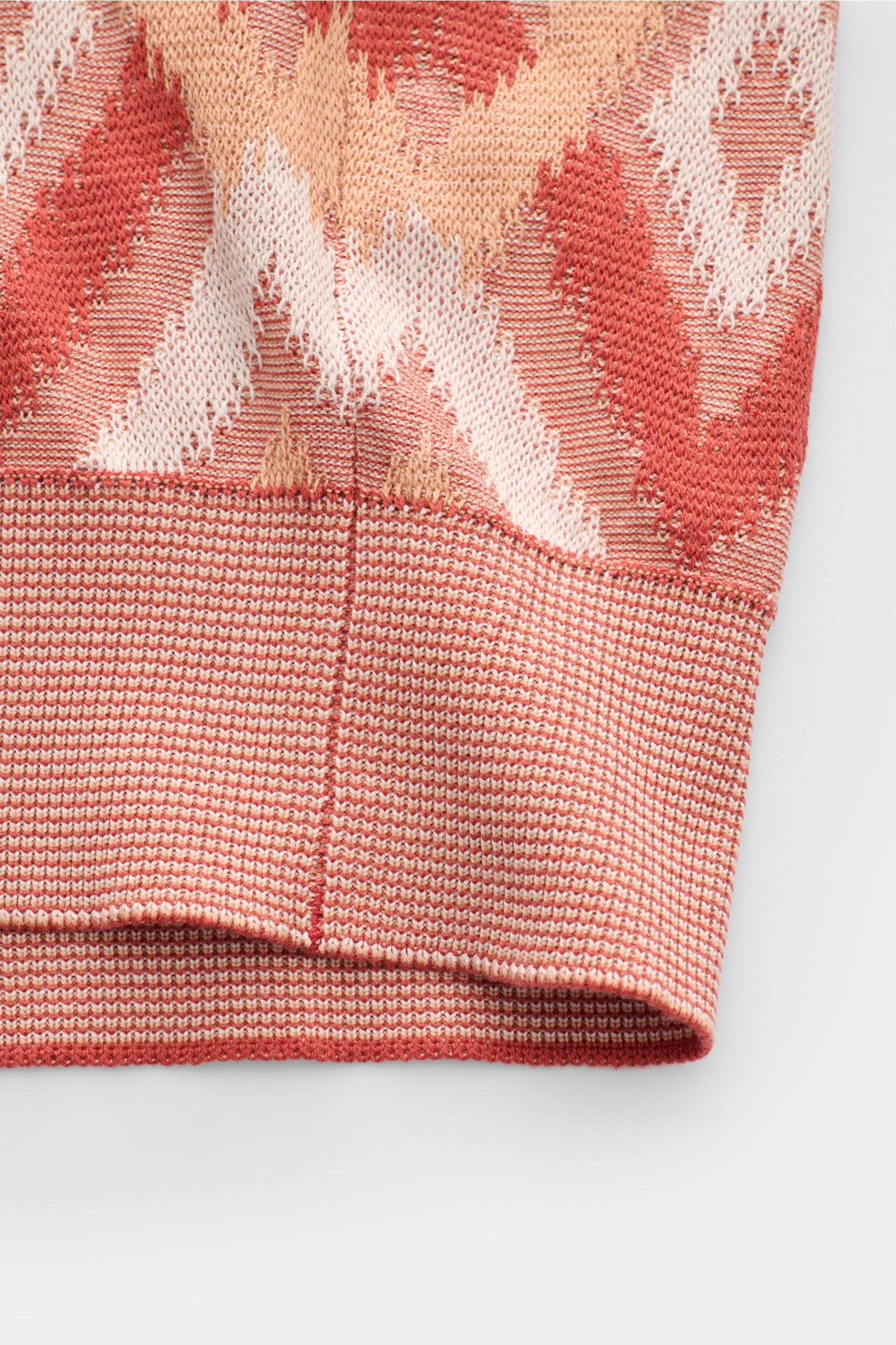 Nahaufnahme eines Ärmels des Piacenza 1733 Cardigan rot/apricot/offwhite gemustert, luftiges Strickbild mit Rautenmuster, Rippbündchen.