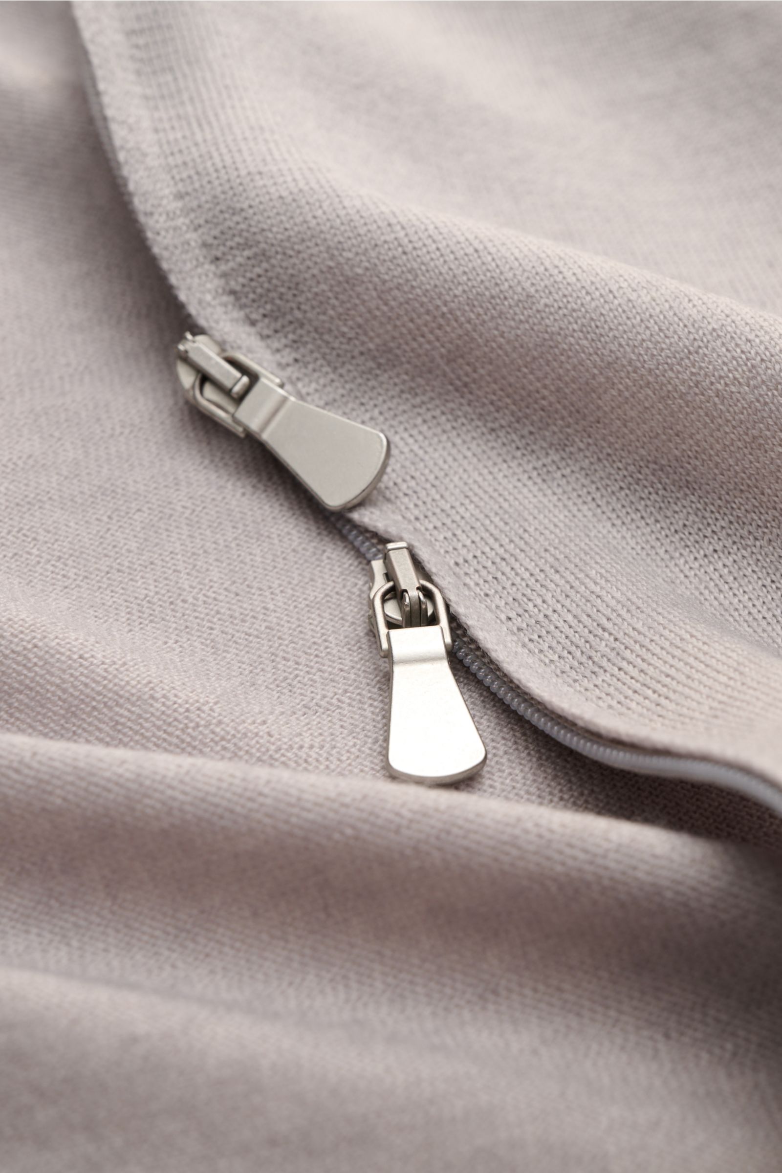 Gran Sasso Strickjacke hellgrau meliert aus reiner Schurwolle, feines Strickbild, Vintage-Finish, zwei-Wege-Reißverschluss nah fotografiert.