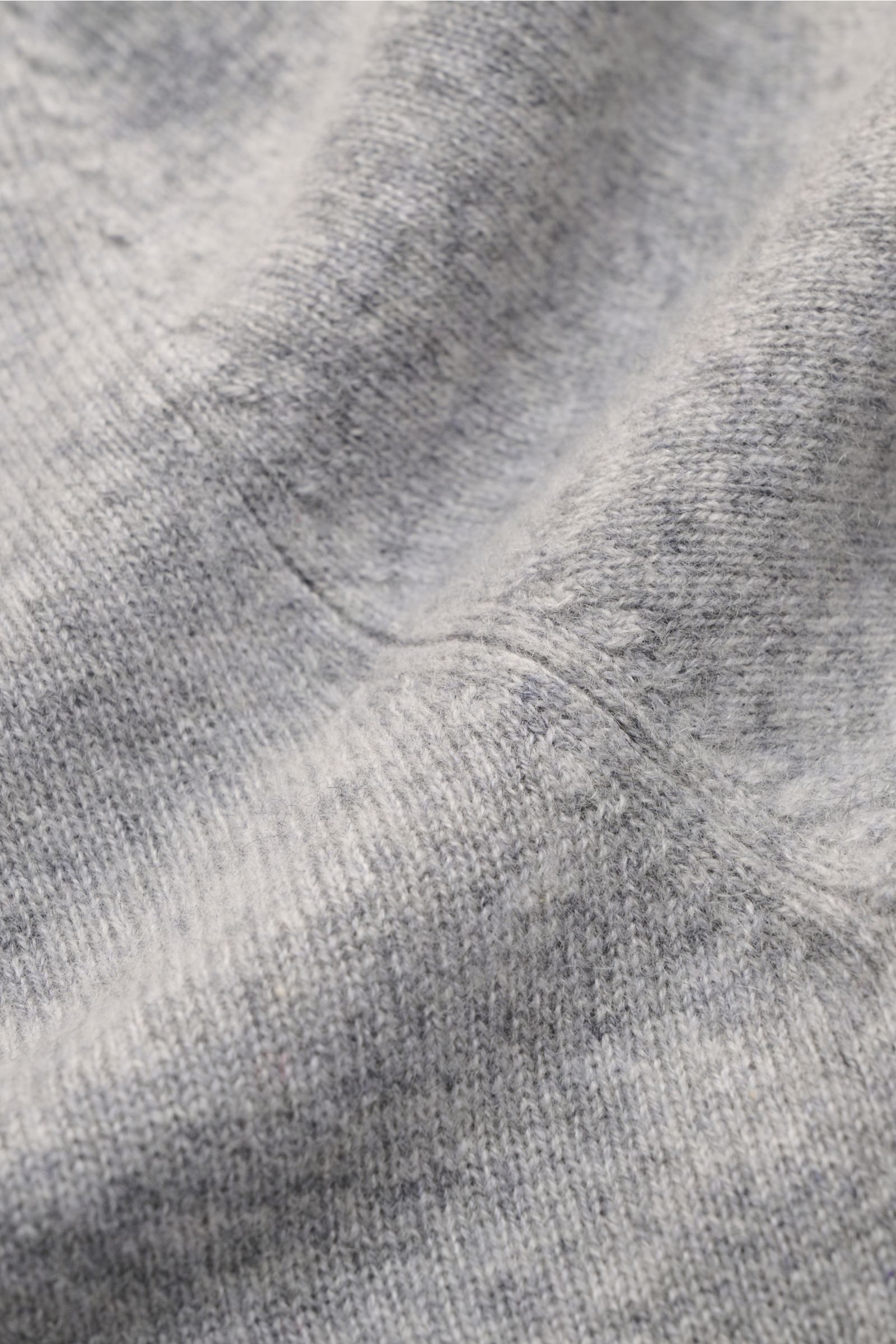 Nahaufnahme der FTC Cashmere Strickjacke grau meliert aus Fair-Trade-Cashmere mit feinem Strickbild und weichem Griff.