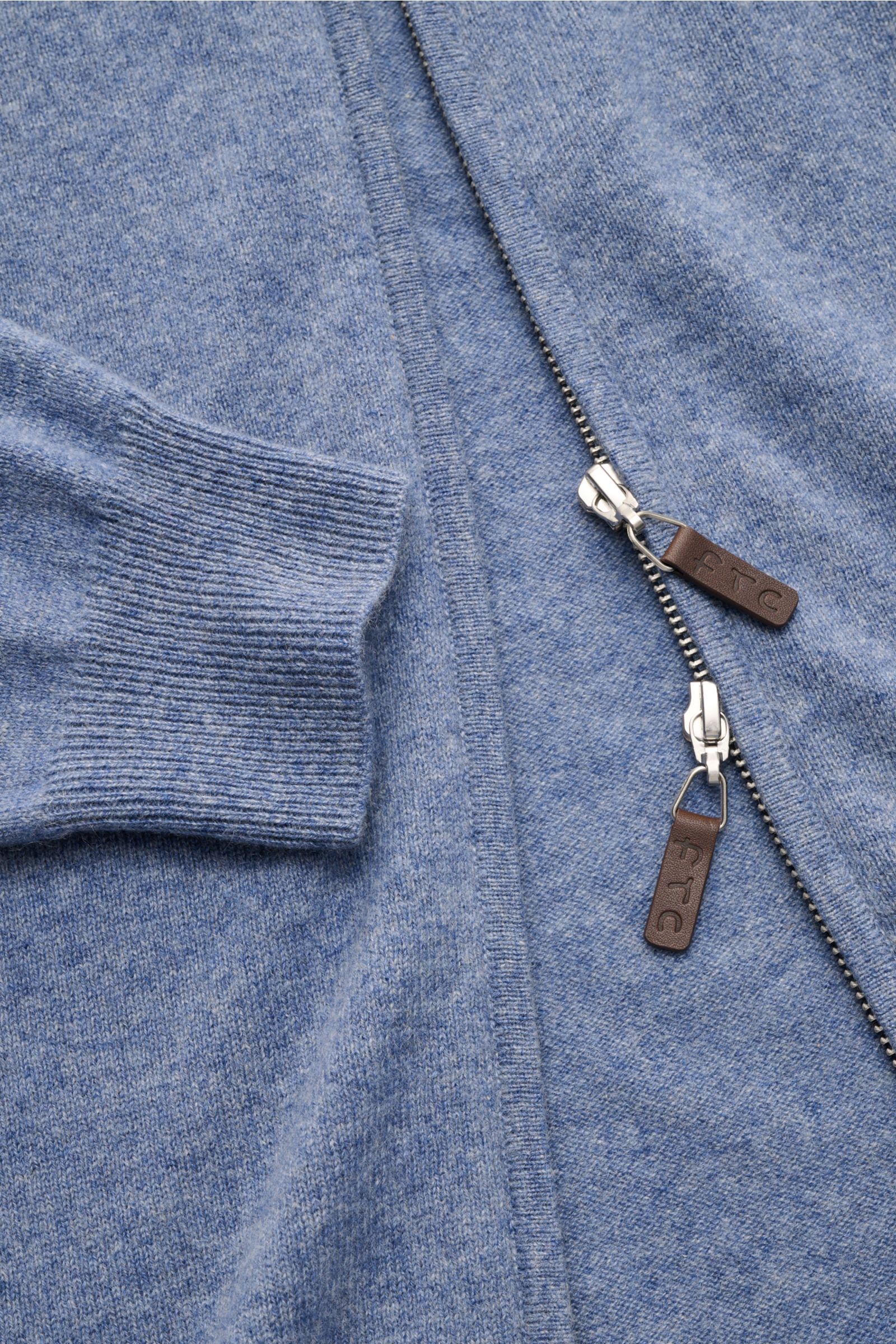 Nahaufnahme der FTC Cashmere Strickjacke rauchblau meliert, zeigt feines Strickbild, Slim Fit, verdeckten Zwei-Wege-Reißverschluss mit Leder-Zipper und gerippten Bündchen. Fair-Trade-Cashmere, OEKO-TEX® zertifiziert, weich und nachhaltig produziert.