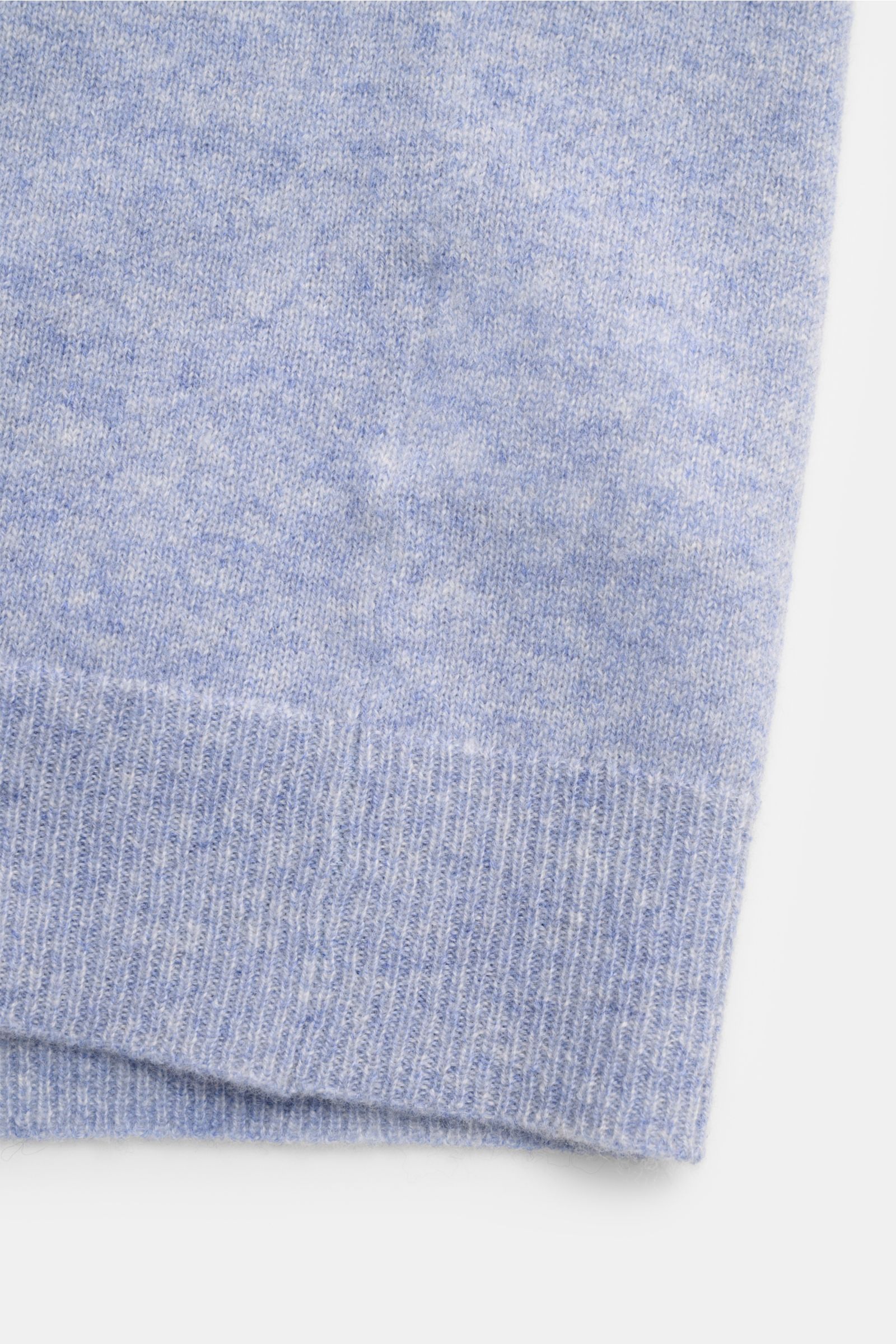 Nahaufnahme der FTC Cashmere Strickjacke hellblau meliert, zeigt das feine Strickbild und gerippte Bündchen aus Fair-Trade-Cashmere.