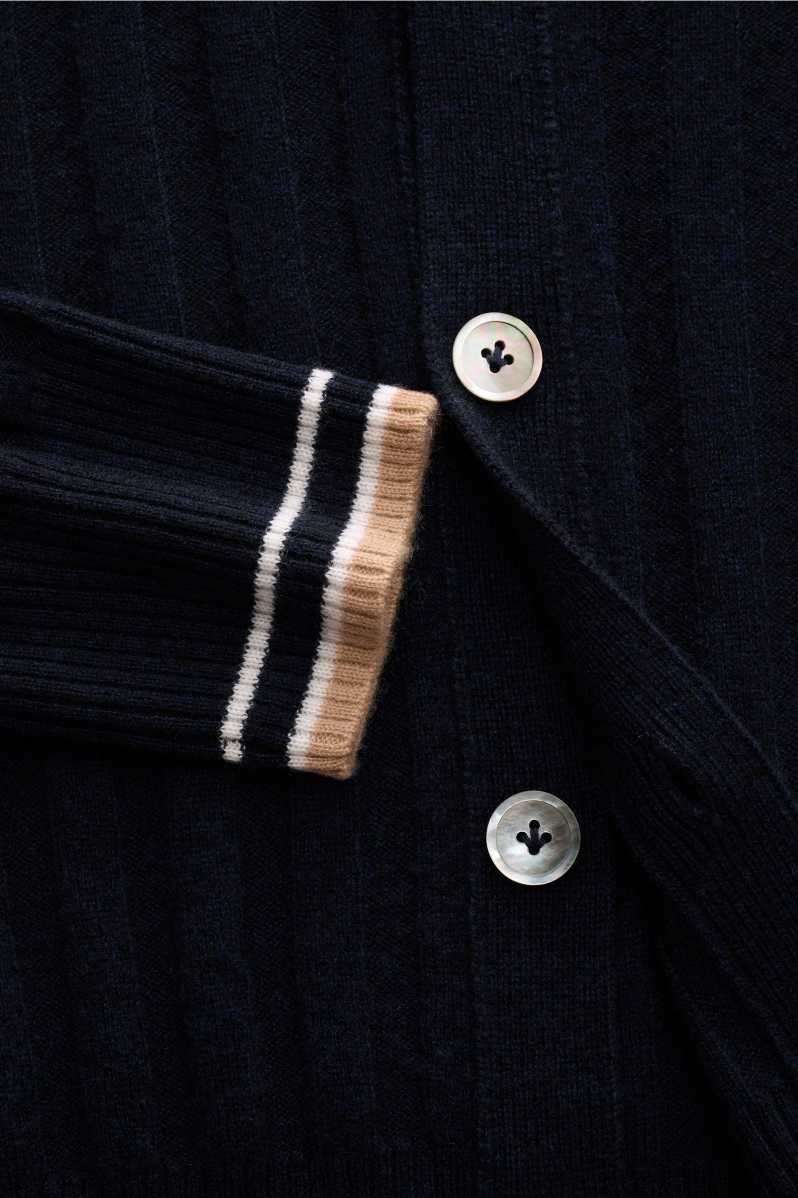 Close-up front view of the FTC Cashmere cardigan navy showing wide rib knit, four mother-of-pearl buttons, and contrasting striped cuff.

This luxurious cardigan by environmentally friendly knitwear label FTC is a soft essential made of pure fair trade
