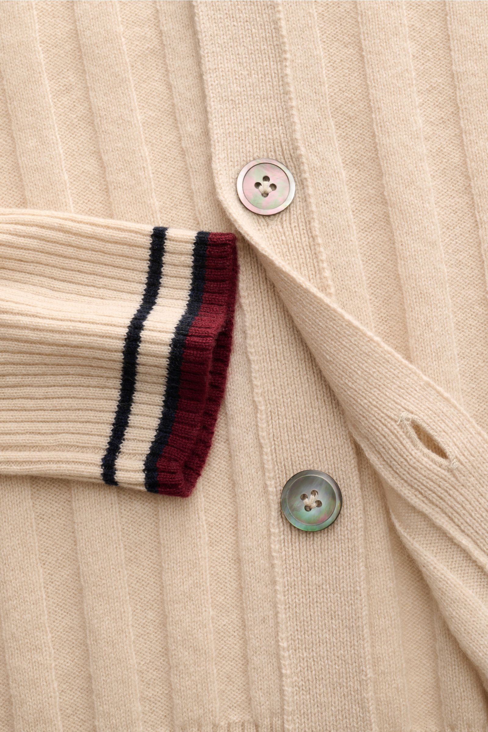 Nahaufnahme des FTC Cashmere Cardigan beige von FTC mit breitem Rippstrick, vier Knöpfen, V-Ausschnitt und kontrastfarbigen Streifen an den Rippbündchen.