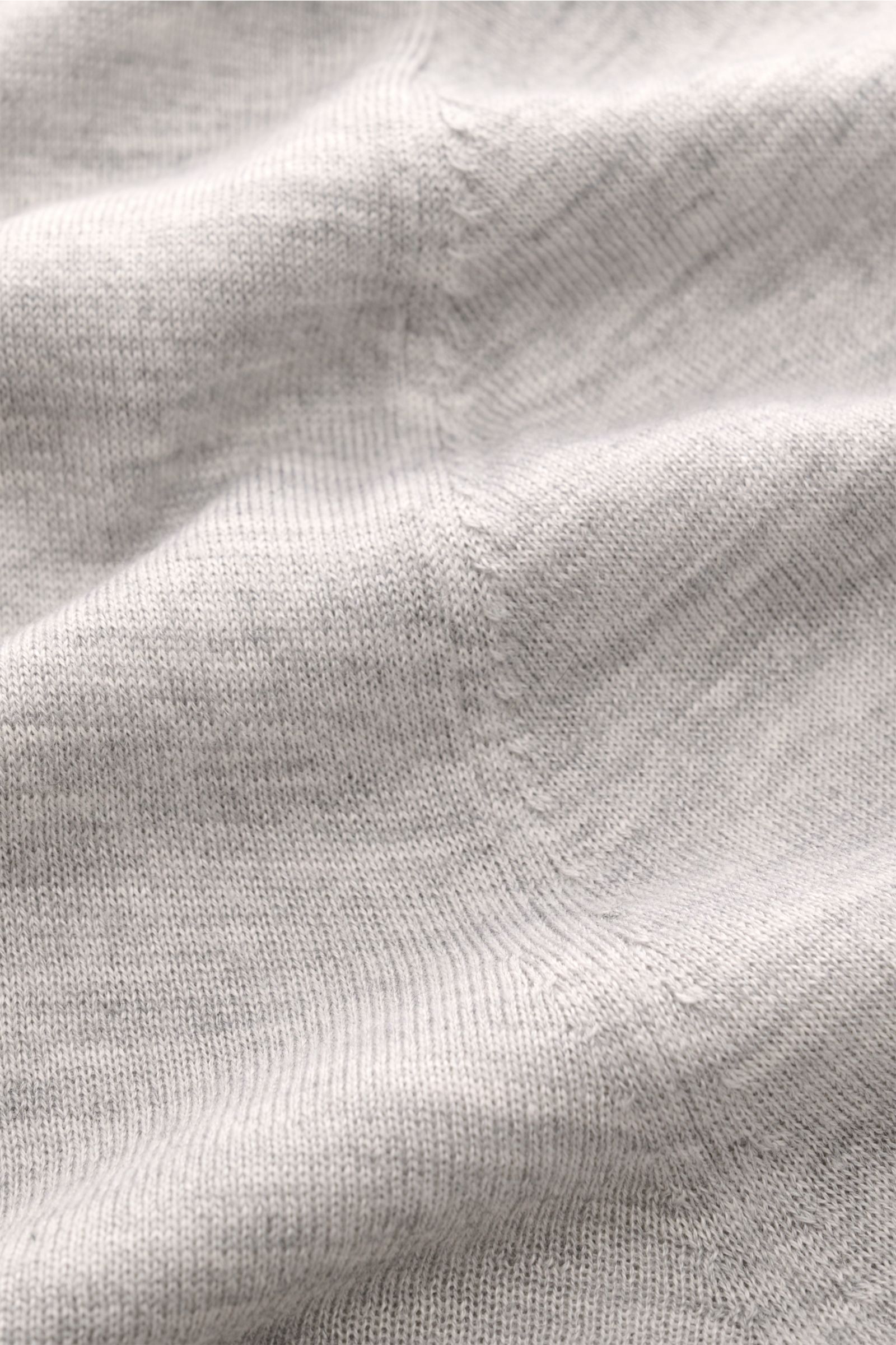 Nahaufnahme des weichen, fein gestrickten FTC Cardigan grau meliert aus Fair-Trade-Cashmere und SeaCell, Detailansicht des Strickbilds.