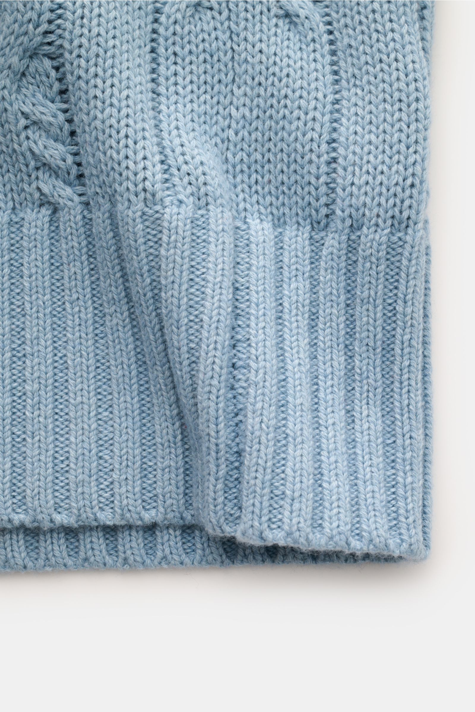 Nahaufnahme des FTC Cardigan hellblau aus Bio-Baumwolle und Fair-Trade-Cashmere mit Zopfstrick, Rippbündchen und Leistentaschen.