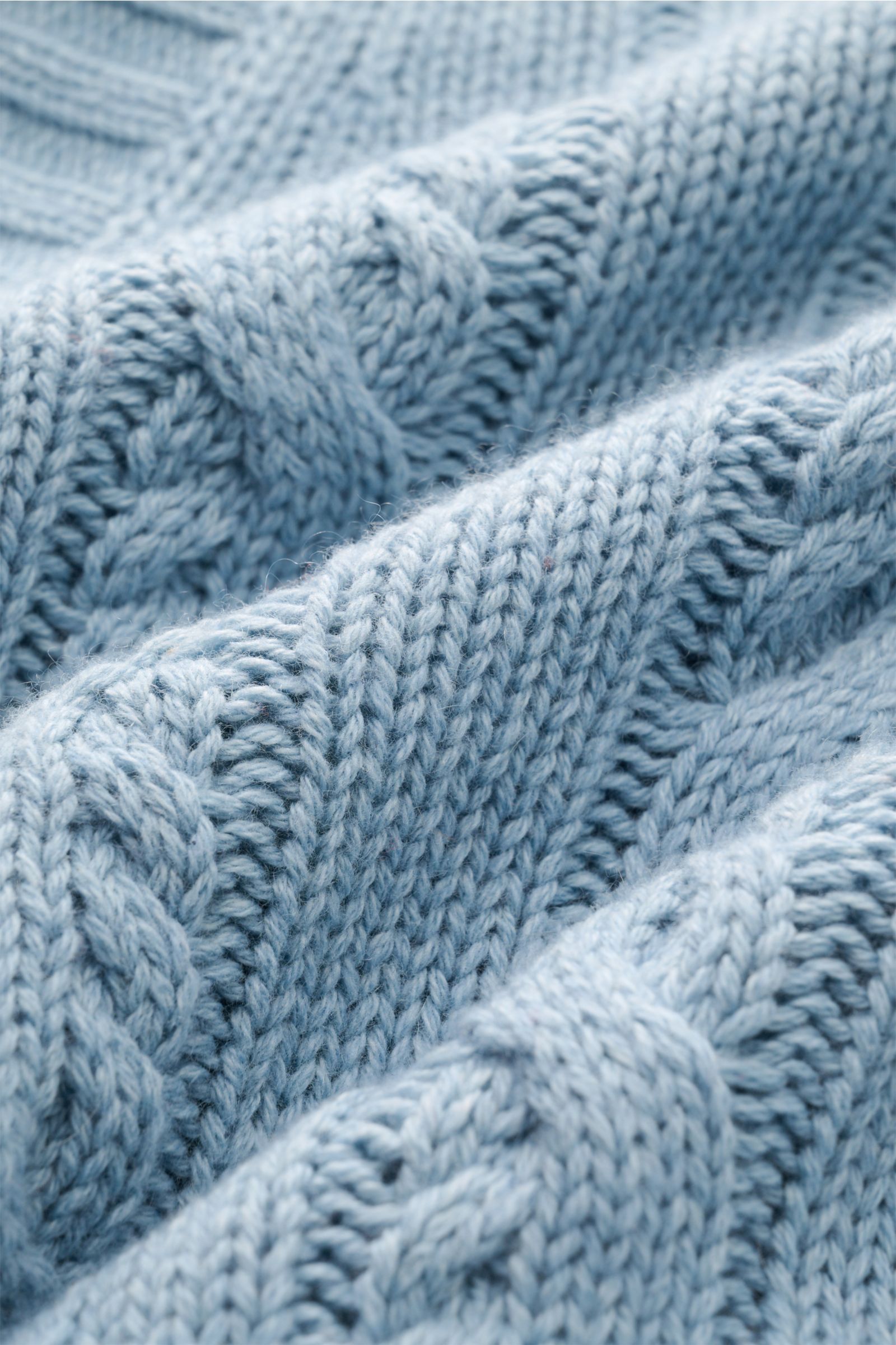 Nahaufnahme des hellblauen FTC Cardigan mit Zopfstrick-Design, weichem Griff und mittelgrobem Strickbild aus Bio-Baumwolle und Cashmere.