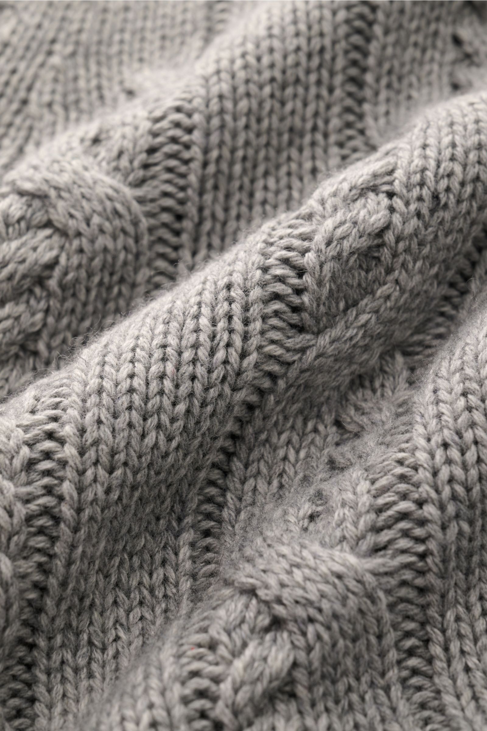 Nahaufnahme des FTC Cardigan grau meliert mit Zopfstrick-Design, weichem Griff, mittelgrobem Strickbild aus Bio-Baumwolle und Cashmere.