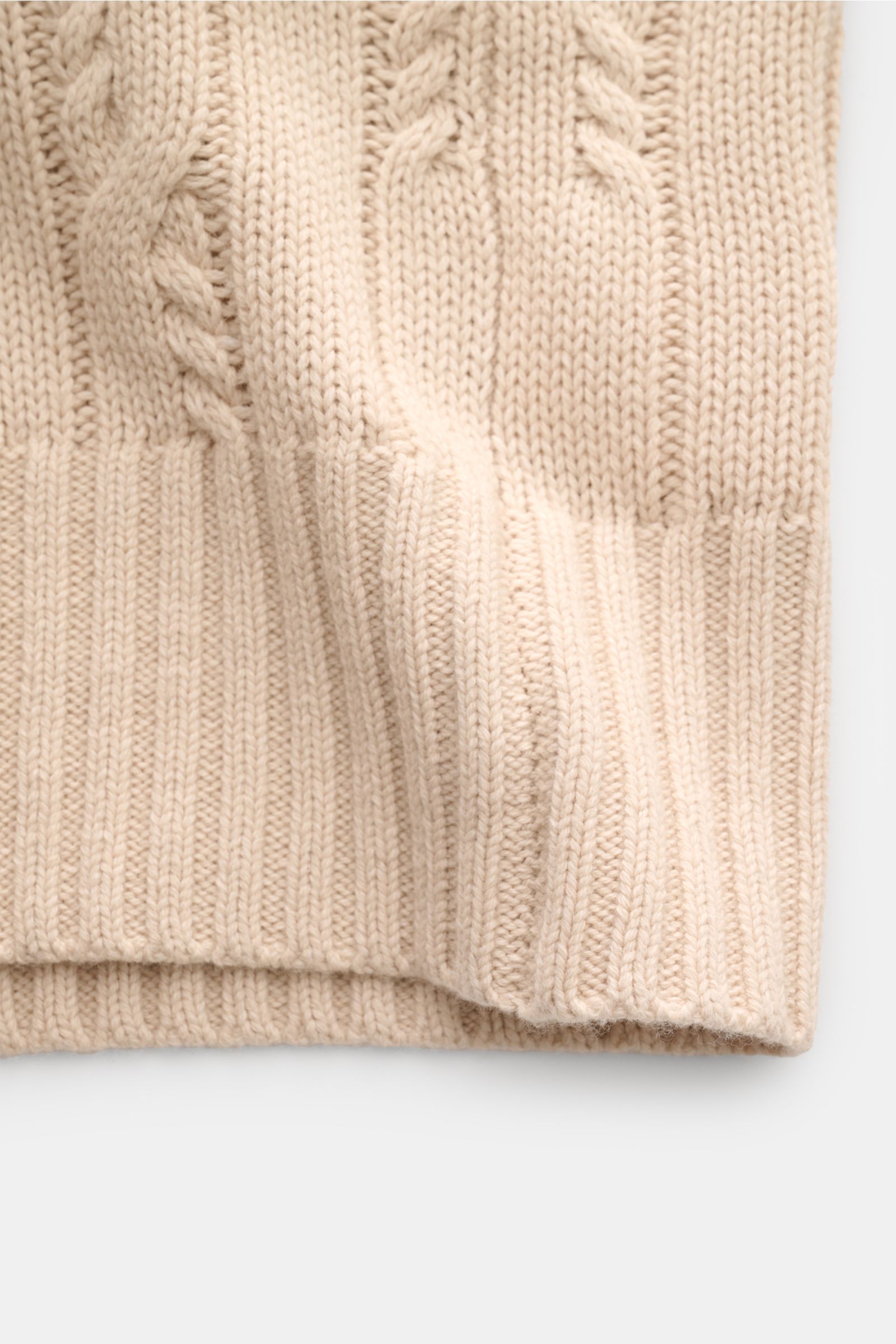 Nahaufnahme des Strickbündchens vom FTC Cardigan beige mit Zopfstrick-Design, weicher Bio-Baumwolle und Fair-Trade-Cashmere.