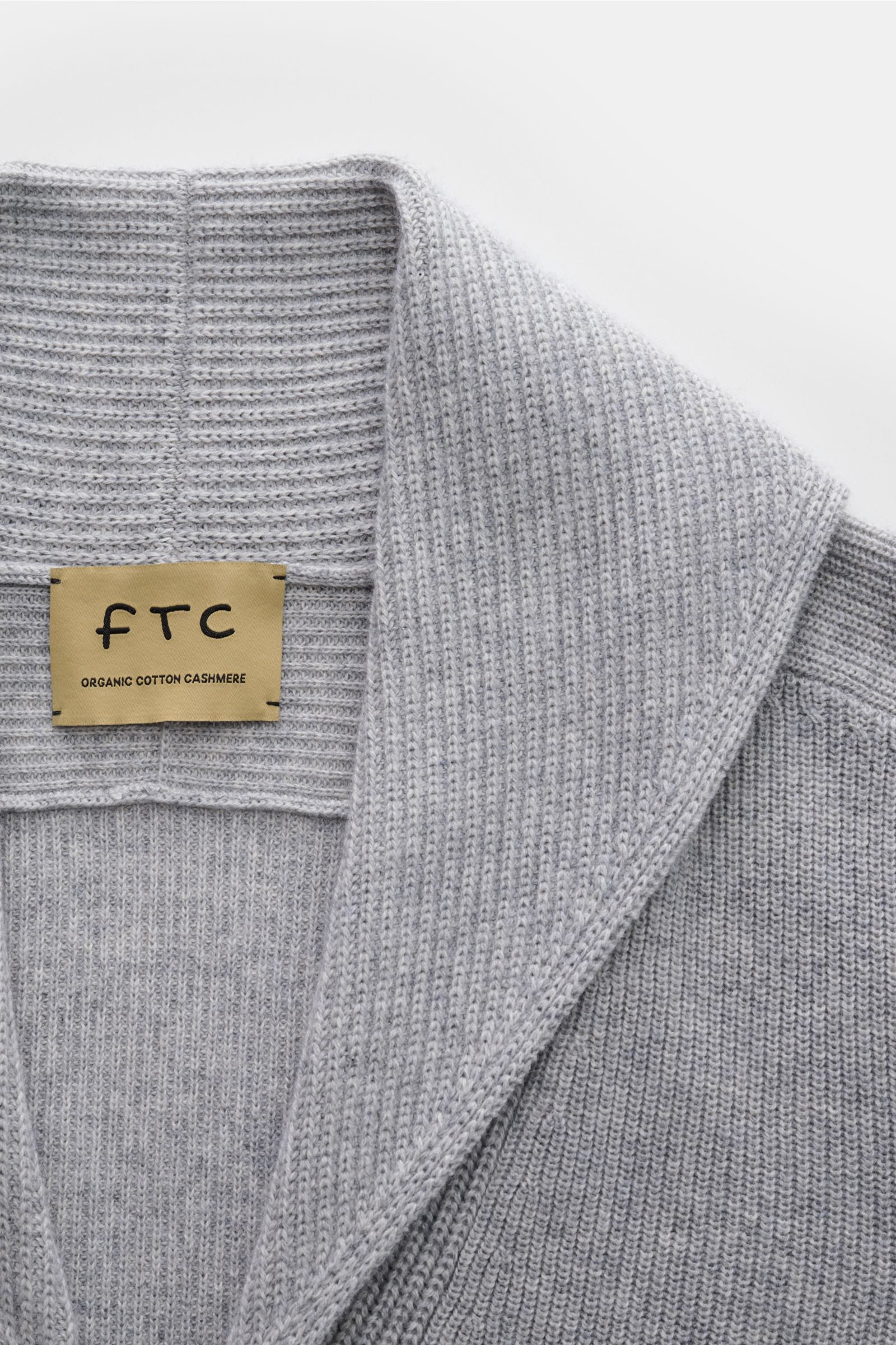 Close-up front view of the FTC Cardigan grey showing the shawl collar and ribbed knit texture.

This luxurious cardigan from sustainable knitwear label FTC is a classic knitted essential made from cotton and fair trade cashmere – and a must-have in any