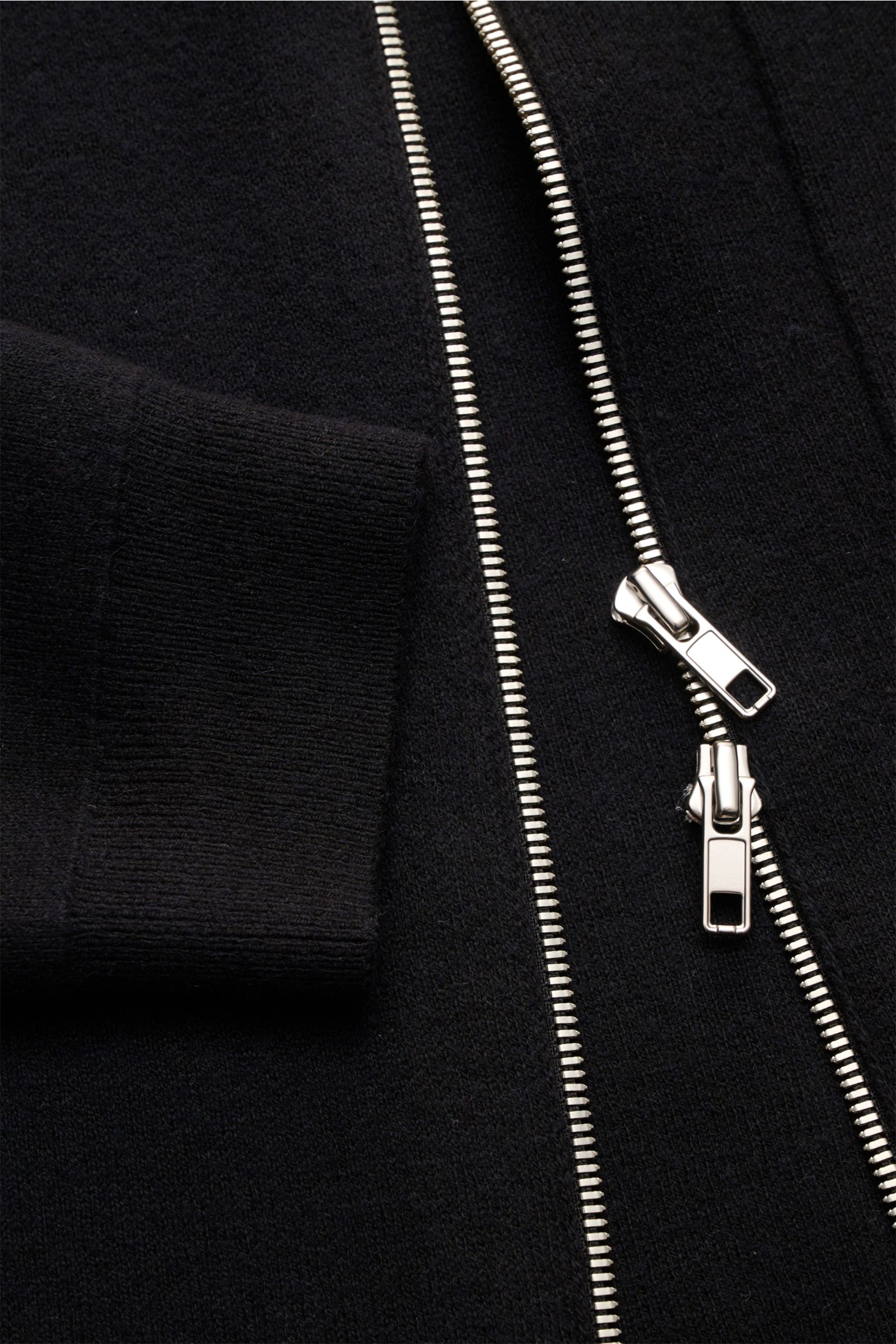 Nahaufnahme der Kiefermann Strickjacke 'Rubern' schwarz mit Slim Fit, zwei-Wege-Reißverschluss, Umlegekragen, Brusttasche und Rippbündchen.