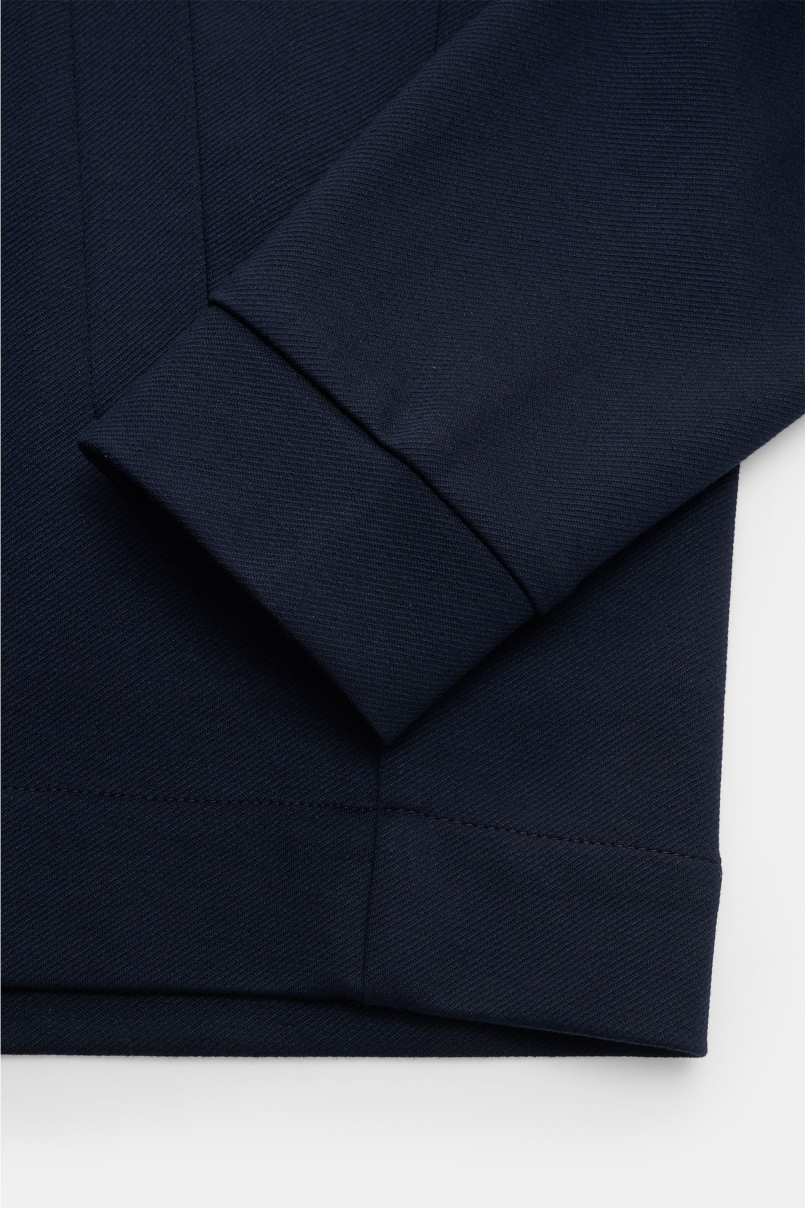 Nahaufnahme der Kiefermann Strickjacke 'Hunfrid' navy, Slim Fit, weicher Jersey aus Viskose und Microfaser, Blouson-Kragen, paspelierte Fronttaschen, Detailansicht von Ärmel und Saum.