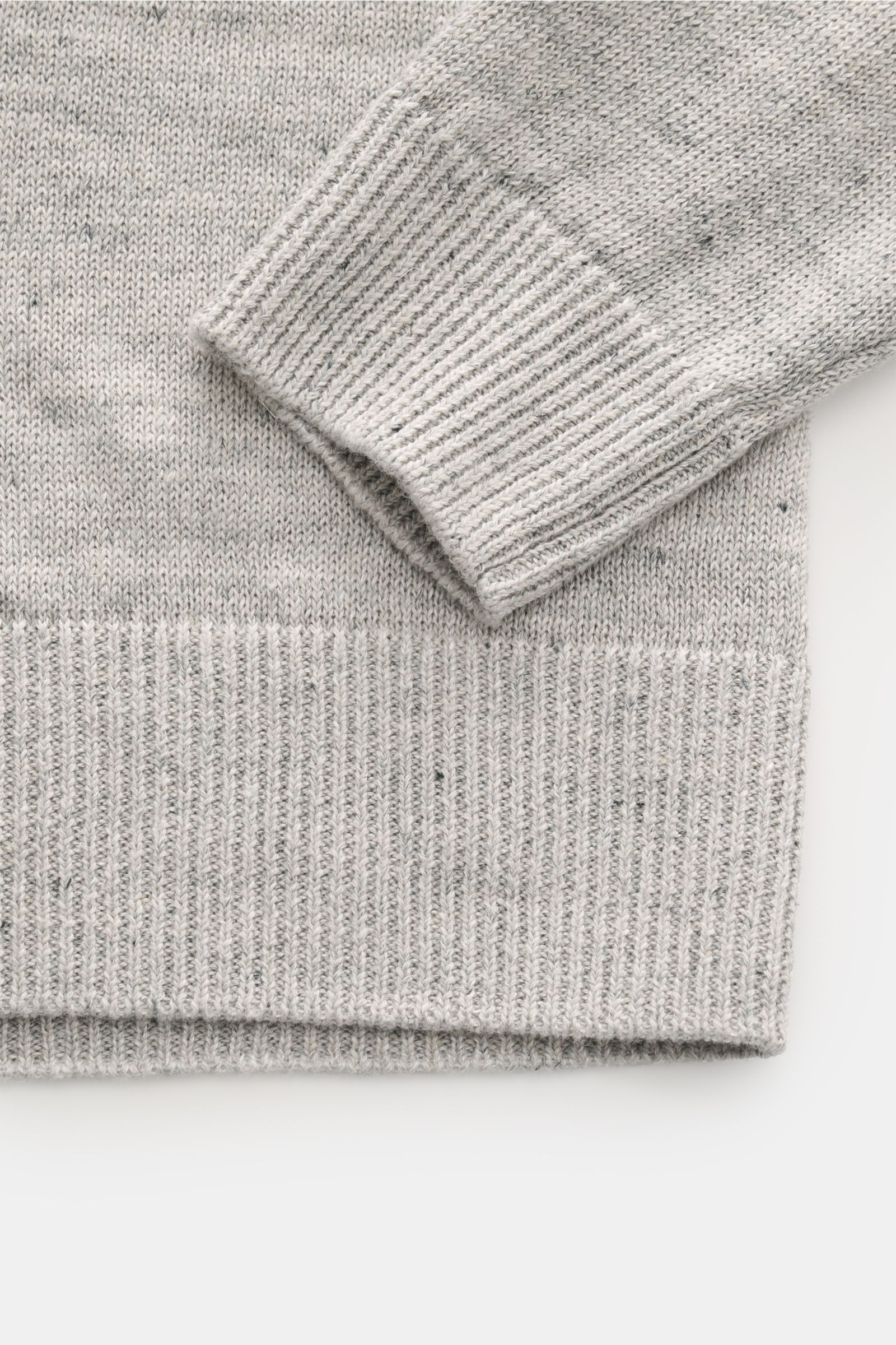 Close-up image of the sleeve and hem of the Filippo de Laurentiis Cardigan grau meliert, showing a fine, lightweight knit with a mix of linen and cotton, soft touch, ribbed cuffs, and hem, photographed from above. Stylisch ohne viel Aufwand: Mit seinem le