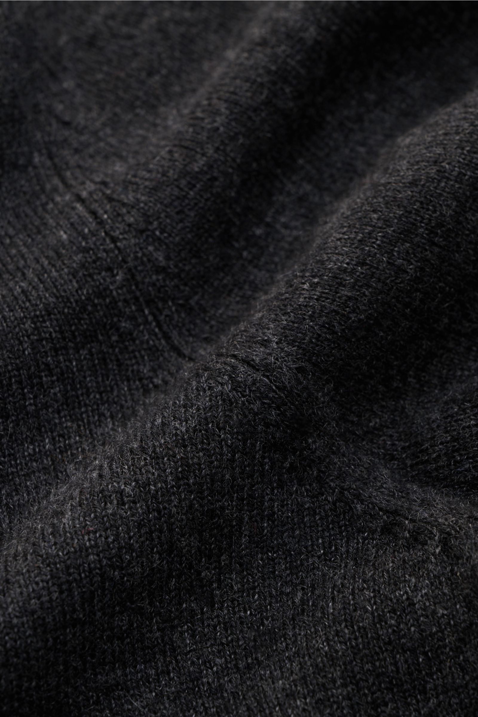 Nahaufnahme des von Braun Cashmere Cardigan dunkelgrau meliert mit feinem Strickbild, weichem Griff und elastischen Rippbündchen.