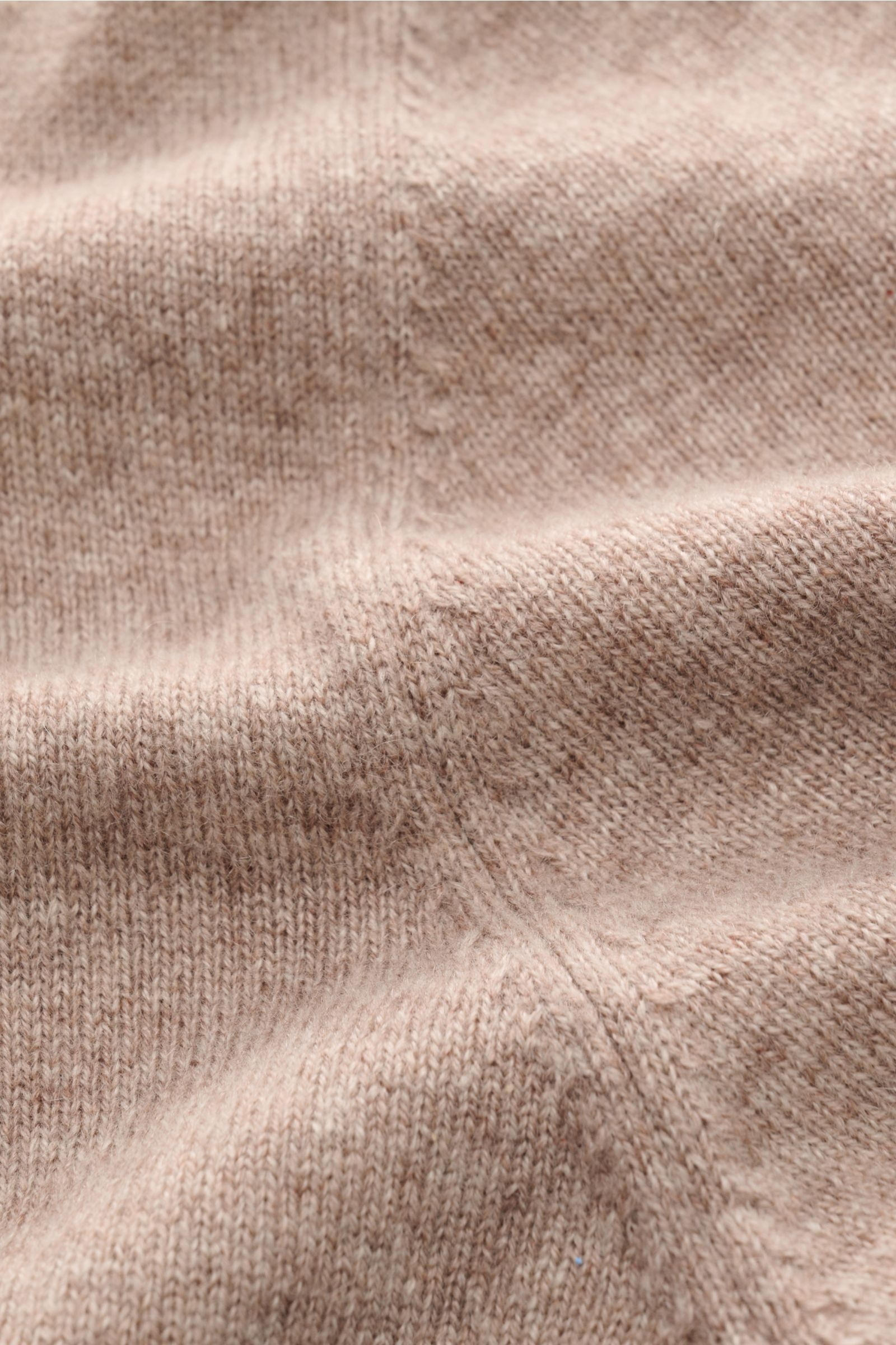 Nahaufnahme der von Braun Cashmere Strickjacke beige meliert aus mongolischem Cashmere, feines Strickbild, weicher Griff, Slim Fit, Reißverschluss, Stehkragen, Rippbündchen. Luxuriöses Basic für kalte Tage, fotografiert aus schräger Perspektive.