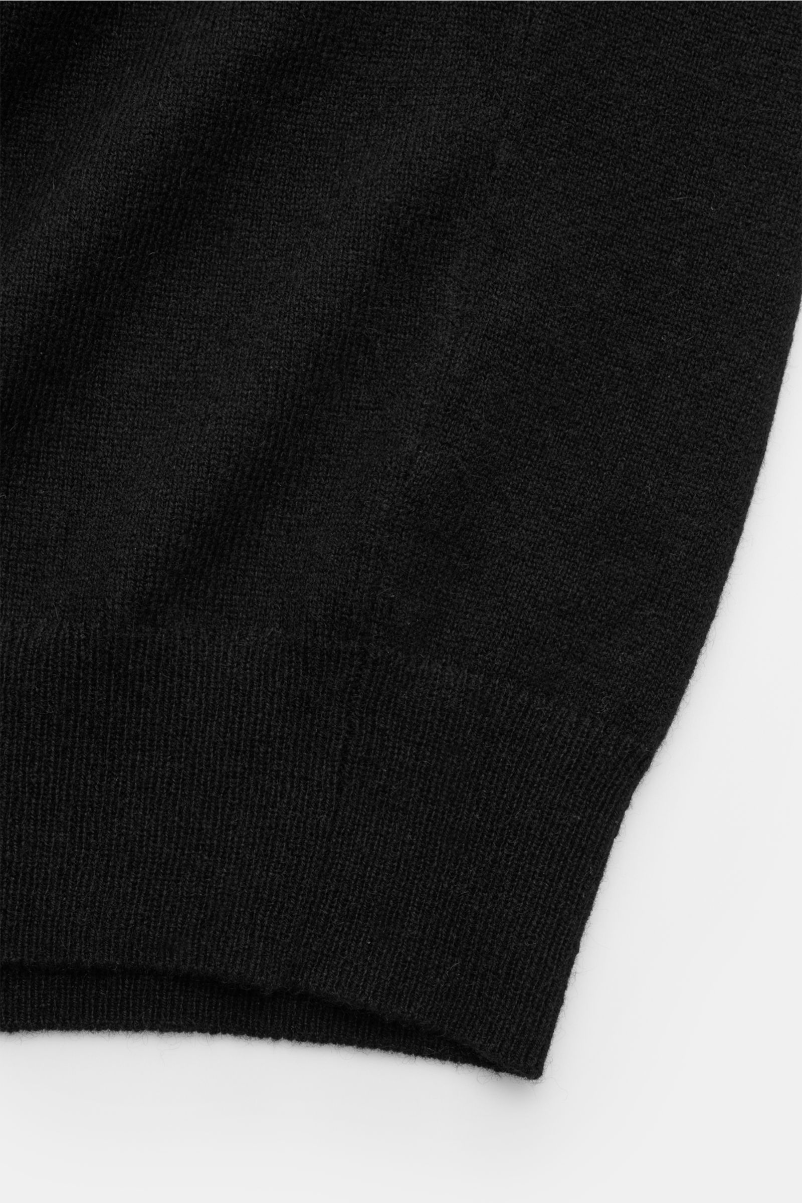 Nahaufnahme der von Braun Cashmere Strickjacke schwarz, Detail des weichen, feinen Strickbilds mit Rippbündchen, Slim Fit, Stehkragen und Reißverschluss, luxoriöses Basic aus reinem mongolischem Cashmere für kalte Tage.