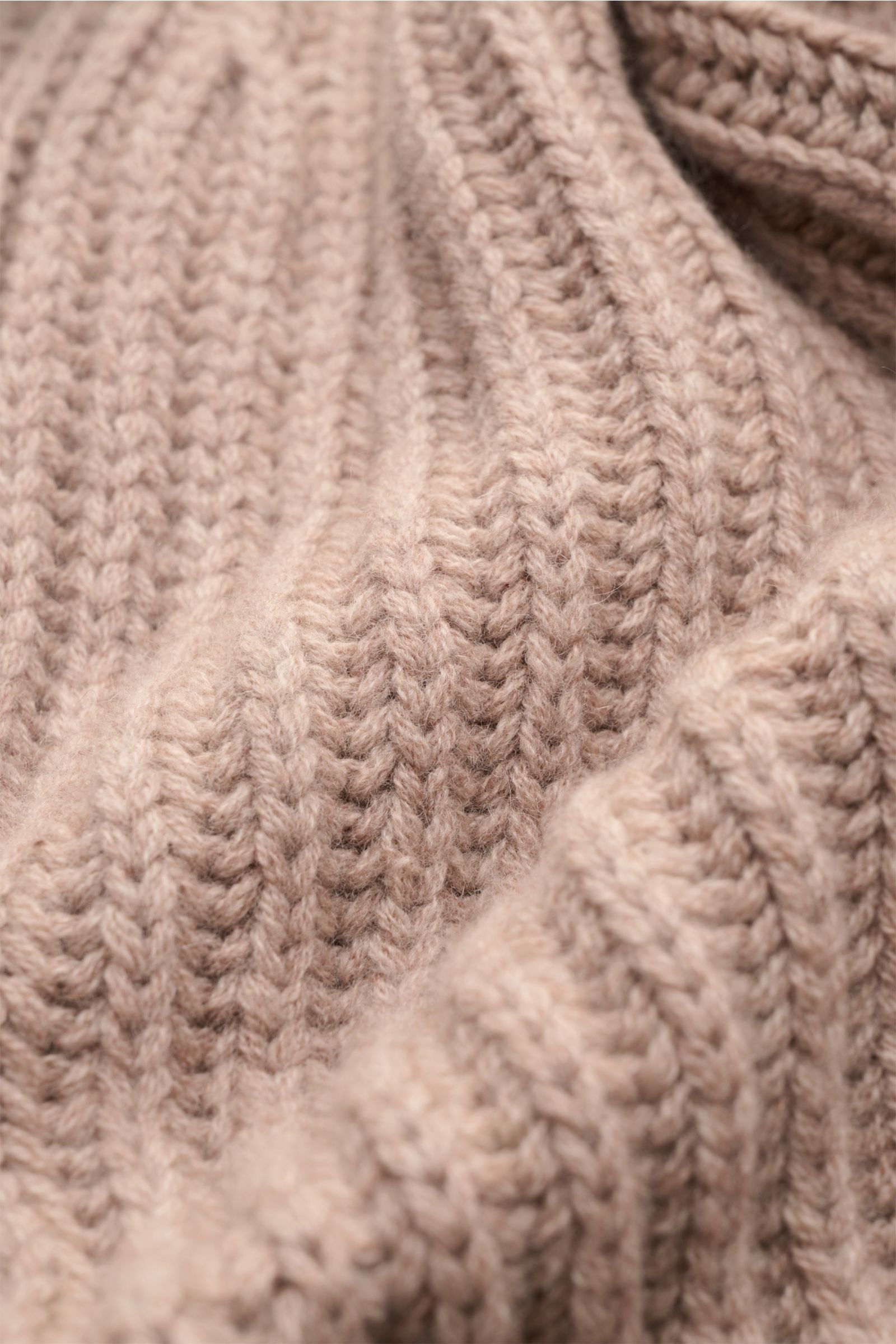 Close-up, angled view of the von Braun Cashmere cardigan beige showing its soft, chunky brioche stitch knit texture. How about a less chunky knit? This cardigan in brioche stitch from the VON BRAUN Cashmere collection is your best defence during the co