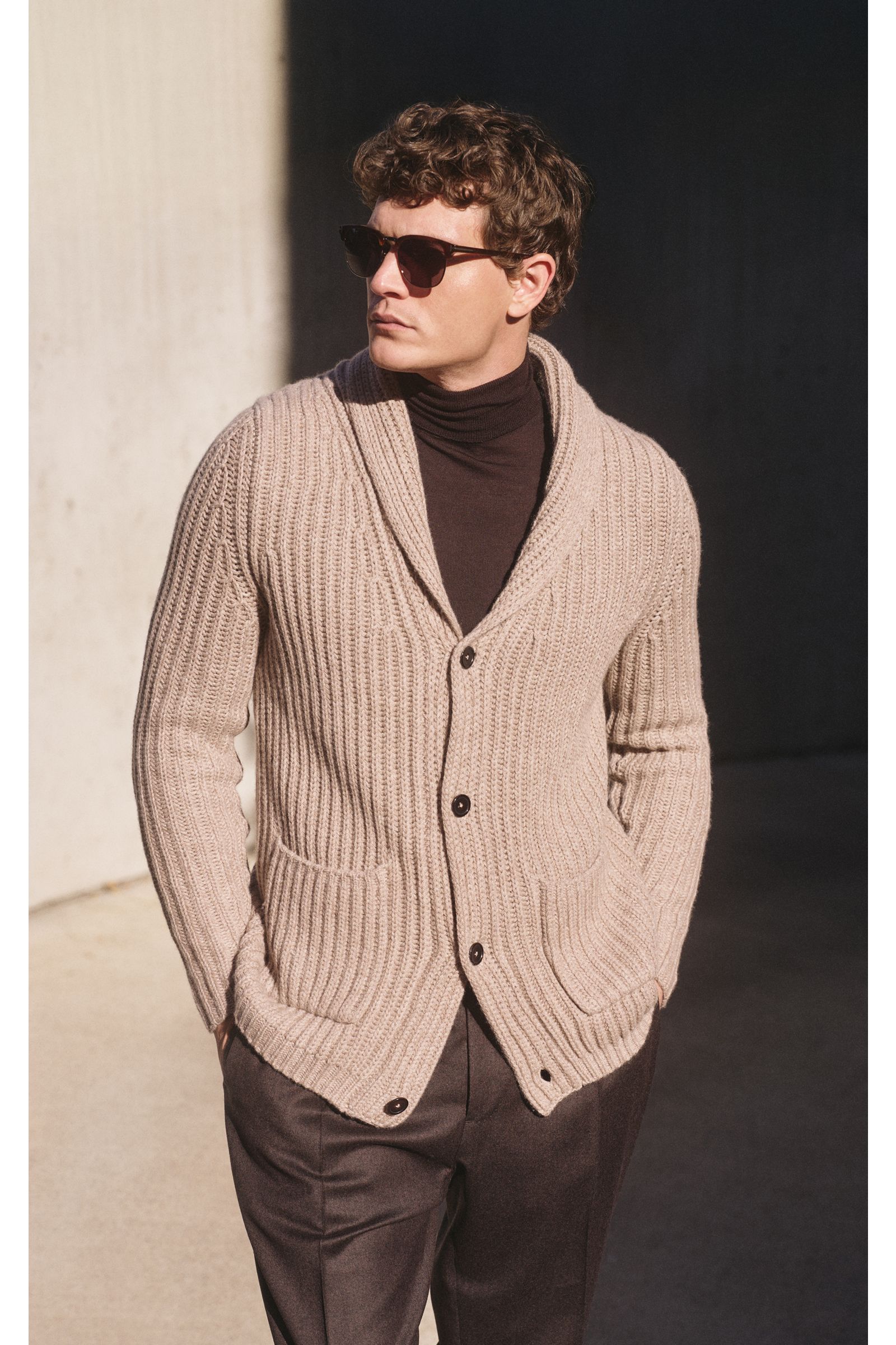 Front view of a man wearing a slim fit von Braun Cashmere cardigan beige in chunky brioche stitch with shawl collar and four-button placket.

Description: How about a less chunky knit? This cardigan in brioche stitch from the VON BRAUN Cashmere collect